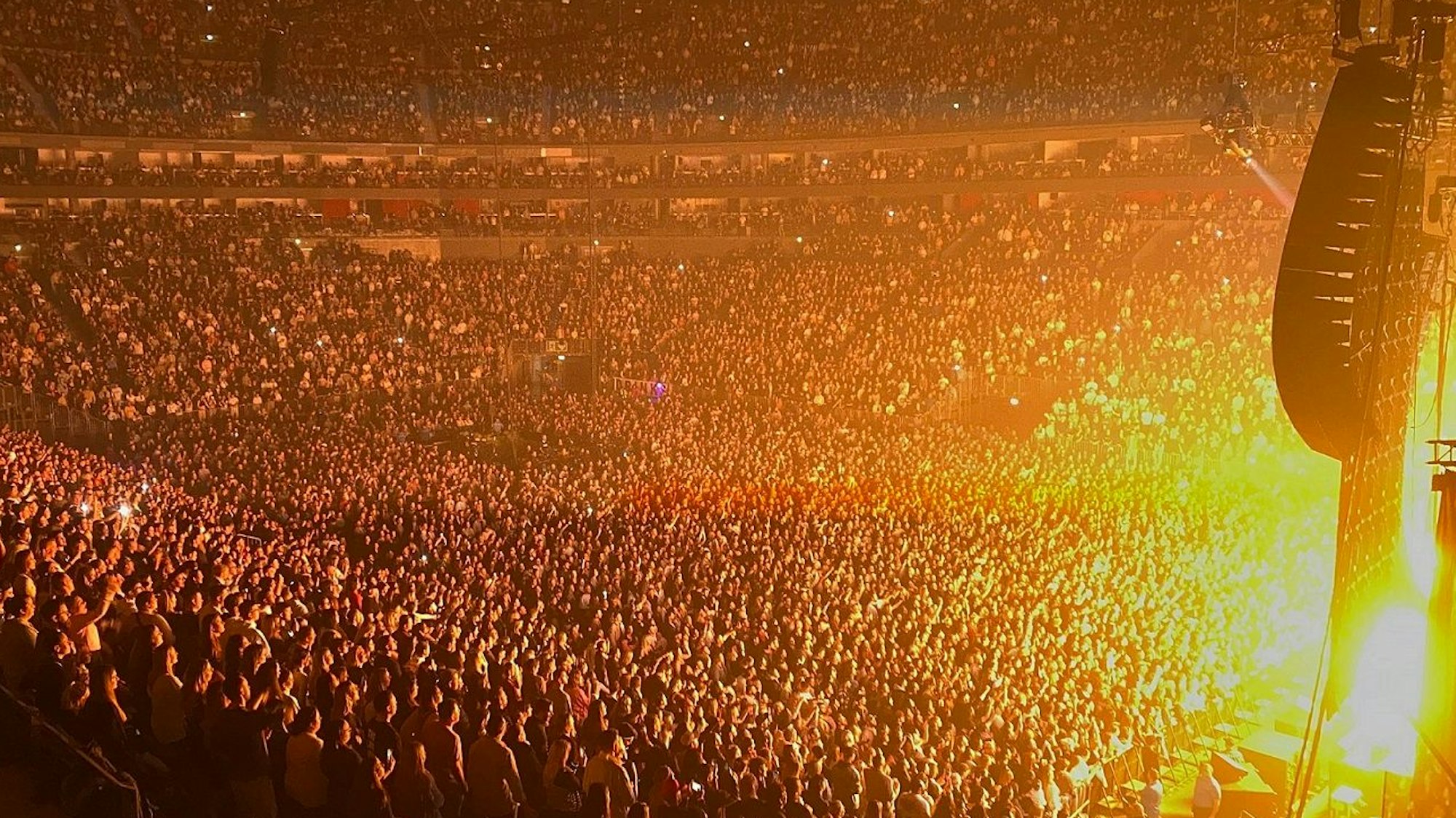 Volles Stadion mit hellem Bühnenlicht rechts