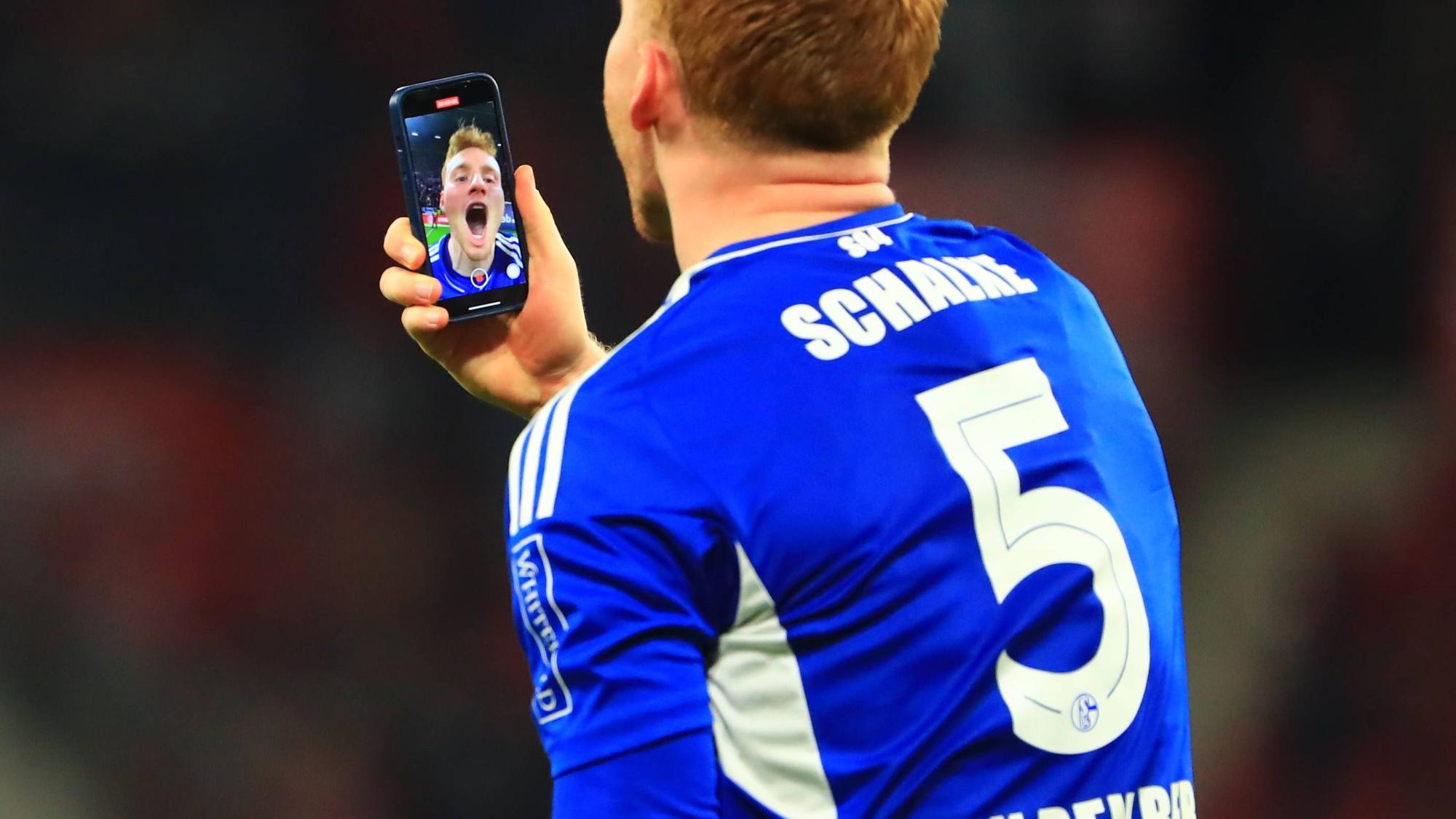 Sepp van den Berg jubelt mit dem Handy nach einem Sieg gegen den FSV Mainz 05.