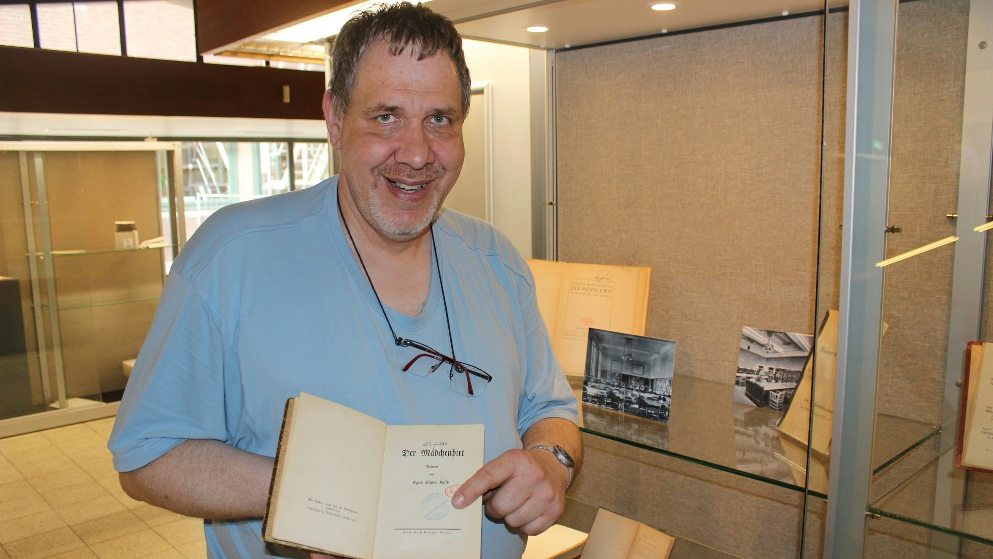 Andreas Freitäger hält ein Buch in den Händen.