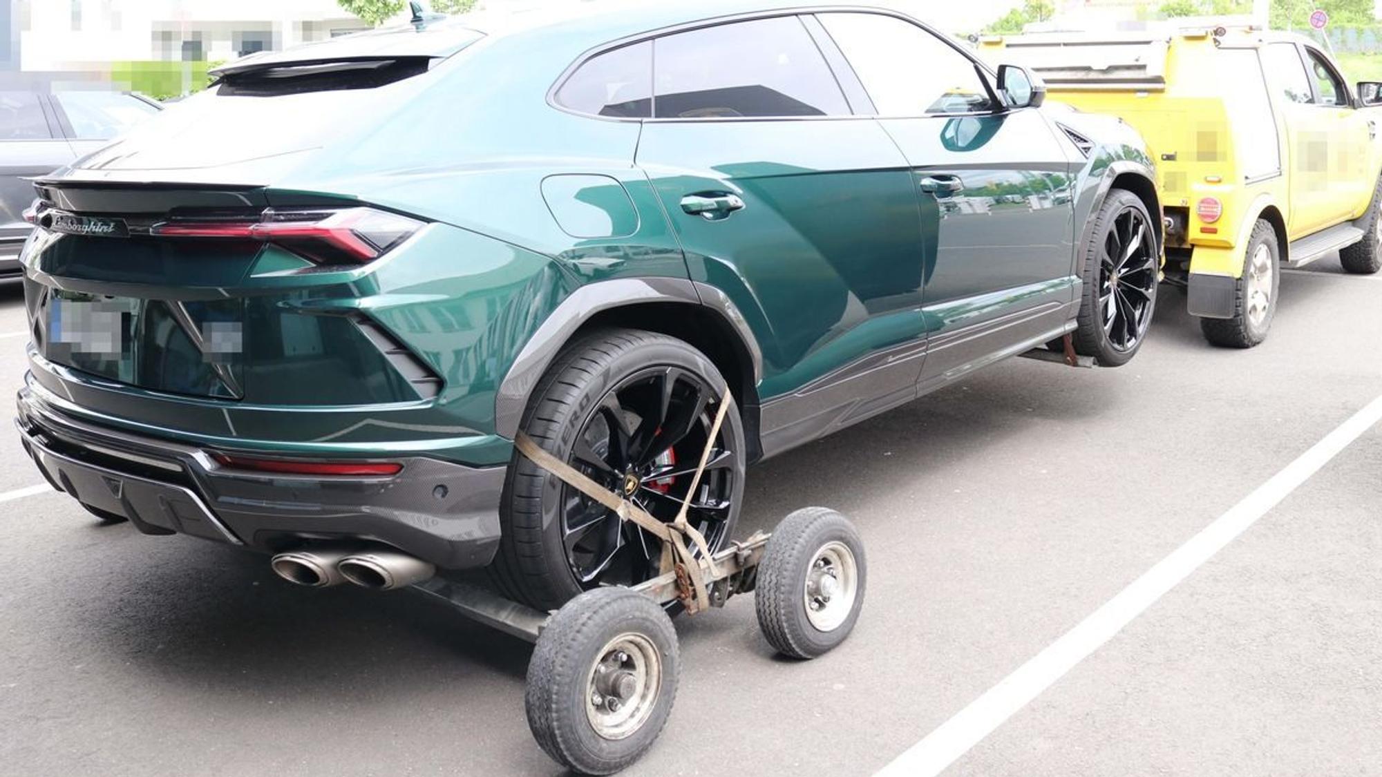 Ein grünes Auto wird von einem gelben Abschleppwagen weggezogen.