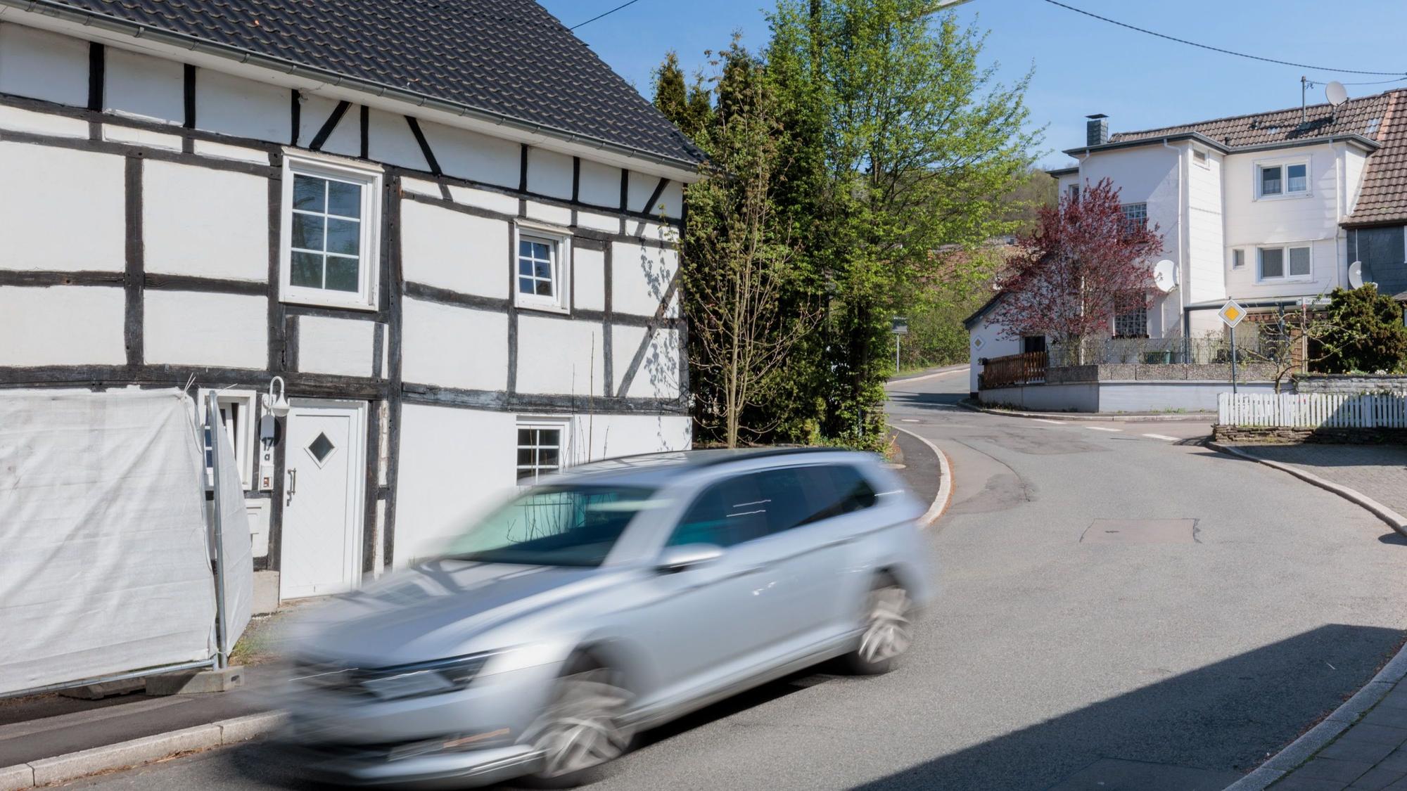 Ein verschwommenes Auto fährt in einer Kurve in Bielstein auf der Dreibholzer Str.