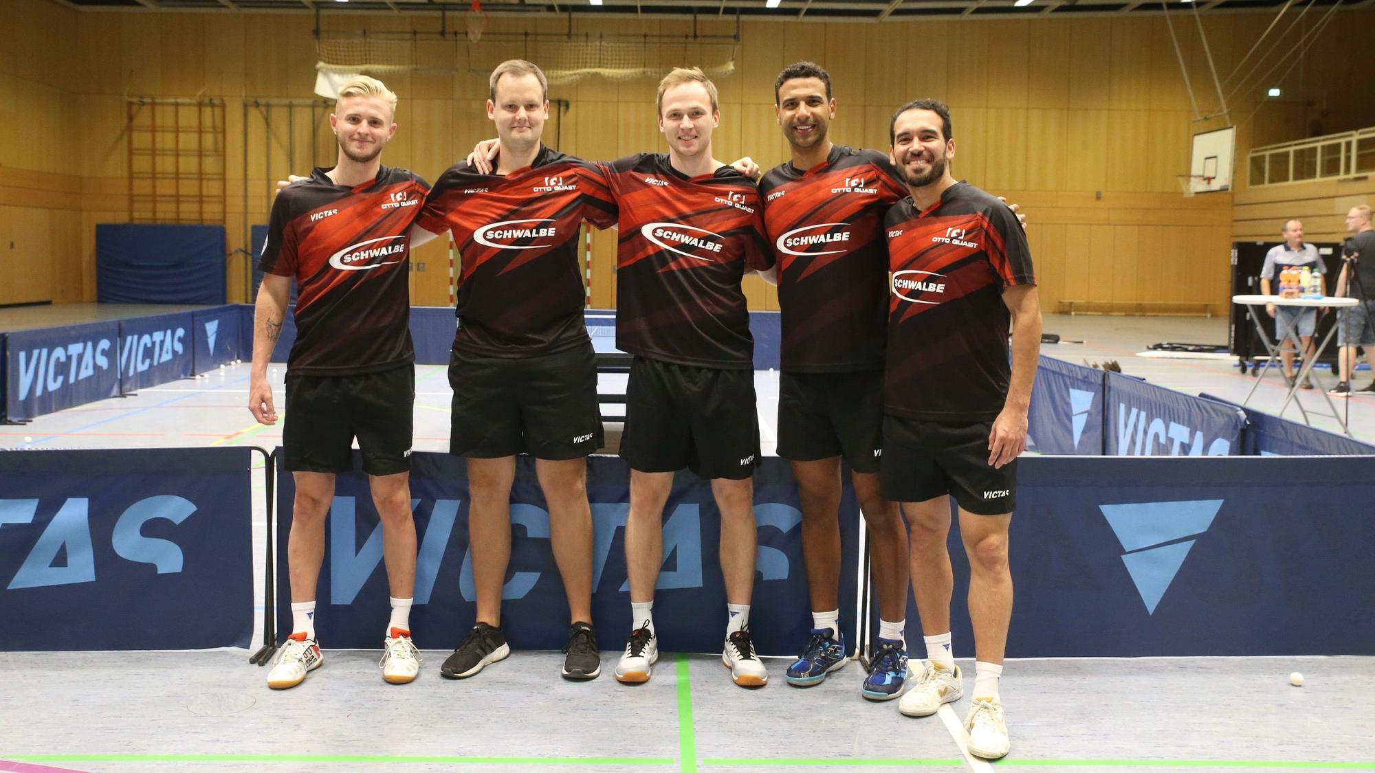 Vier Tischtennisspieler und ihr Trainer stehen Arm in Arm in einer Reihe.