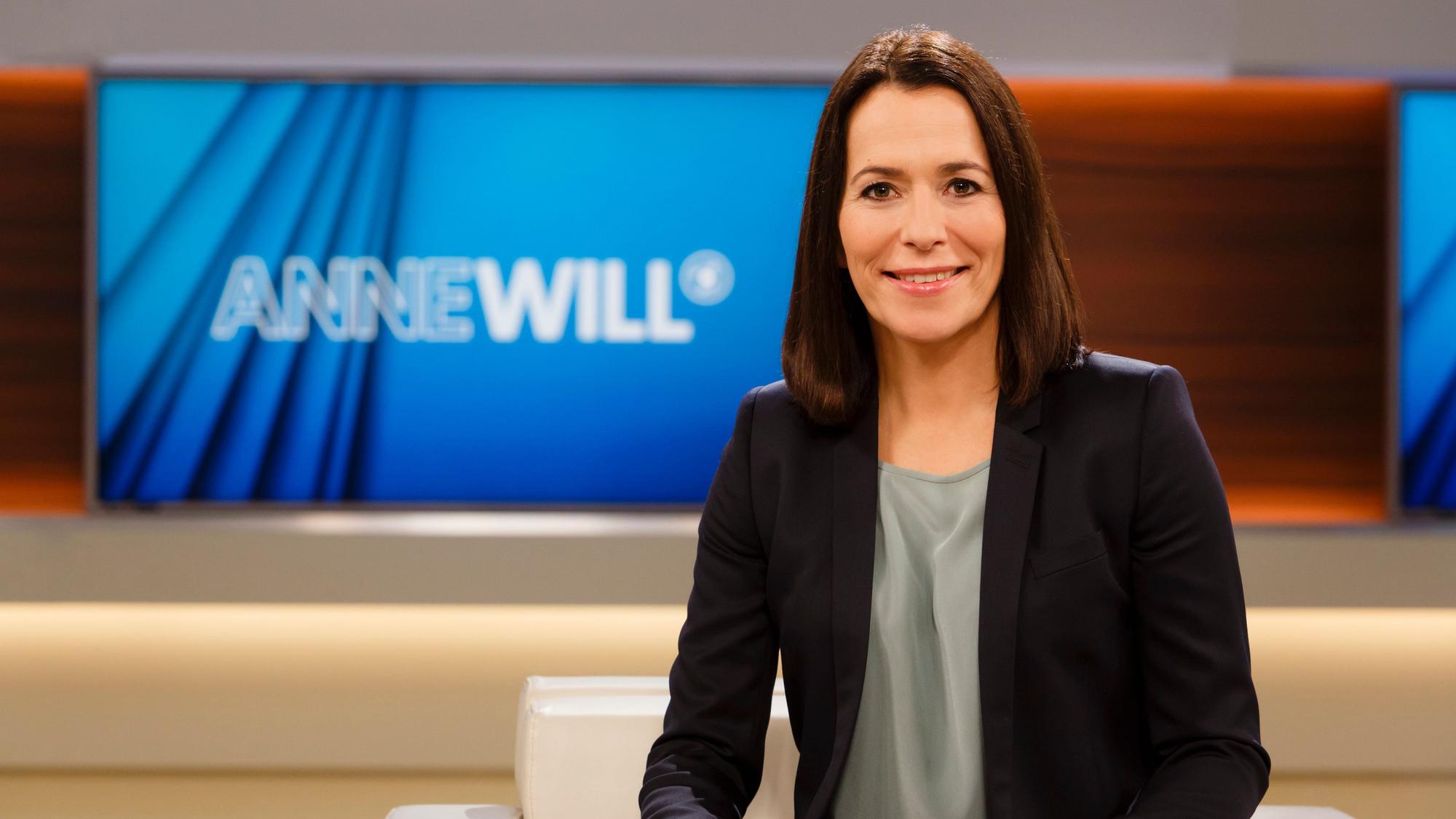 Moderatorin Anne Will sitzt im Studio der Talkshow „Anne Will“ und lächelt in die Kamera.