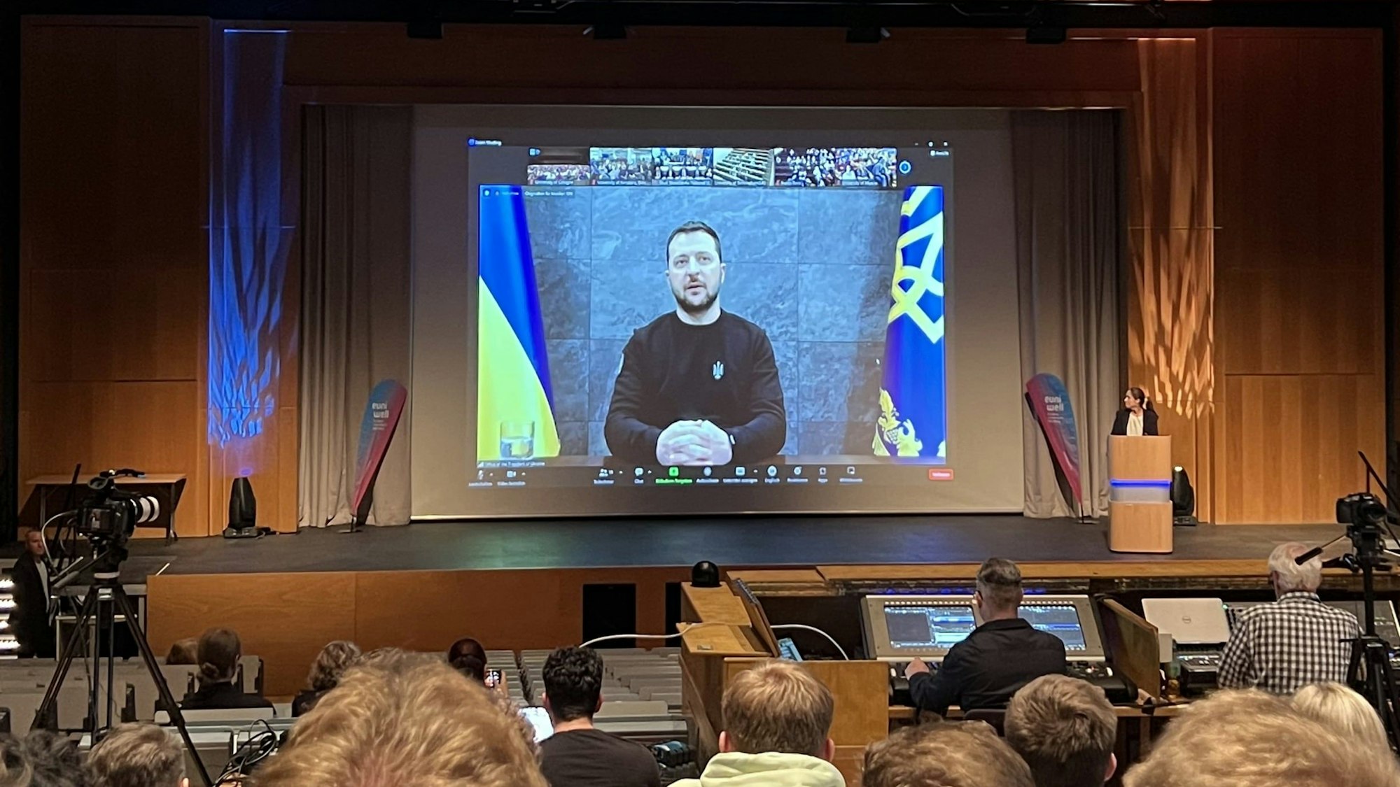 Wolodymyr Selenskyj ist auf einem Bildschirm in einem Hörsaal zu sehen.