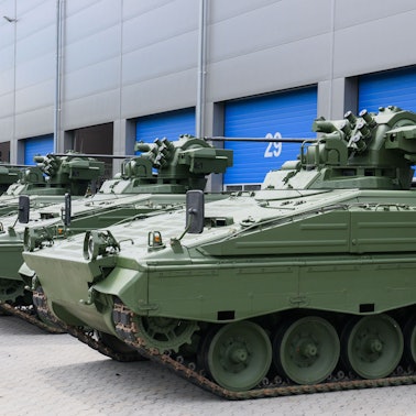 Wieder aufbereitete Marder-Schützenpanzer stehen vor einer Rheinmetall-Halle.