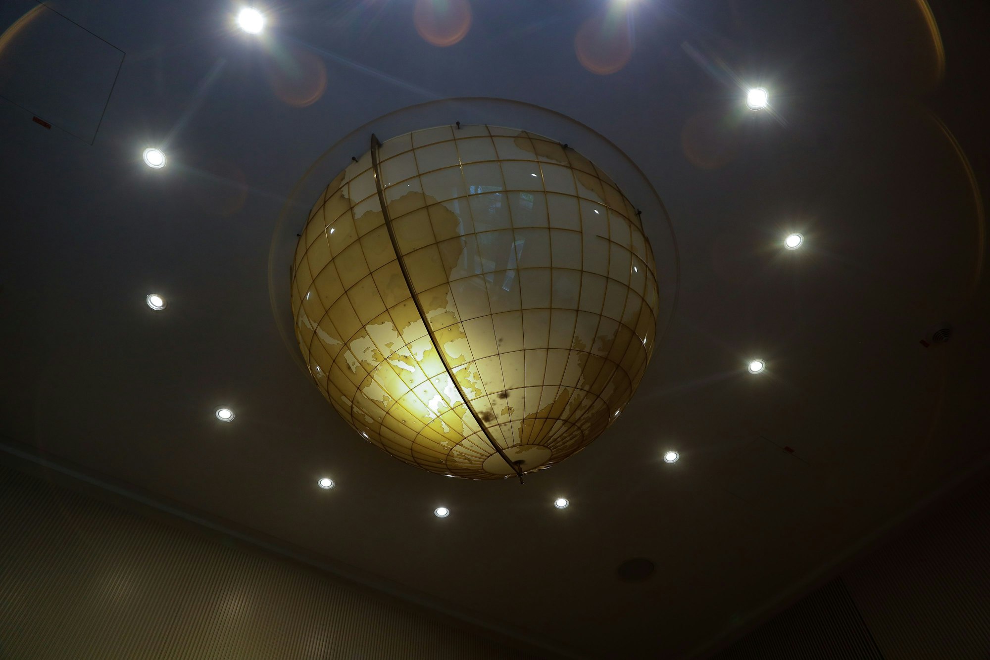 Ein großer, goldfarbener Globus hängt von der Decke.