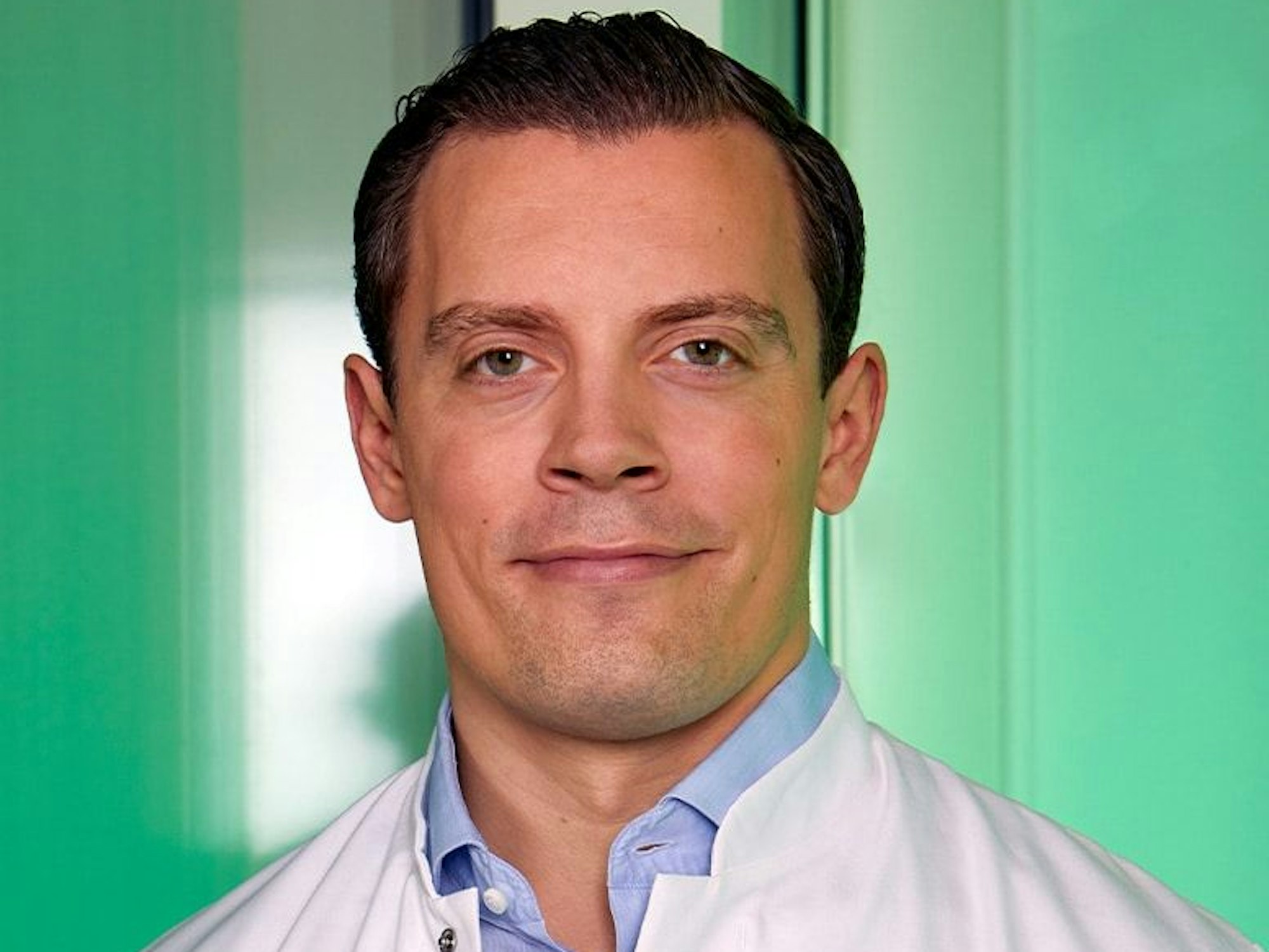 Porträt von Julian Wichmann. Er lächelt in die Kamera.