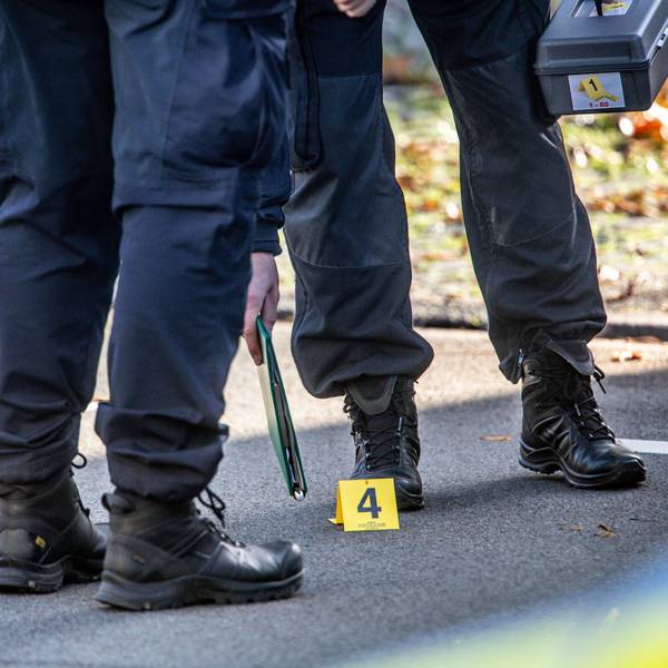 Polizisten sichern einen Einsatzort, nur die Beine der Polizeibeamten sind zu sehen, dazu eine gelbe Ortsmarkierung mit einer Vier darauf.