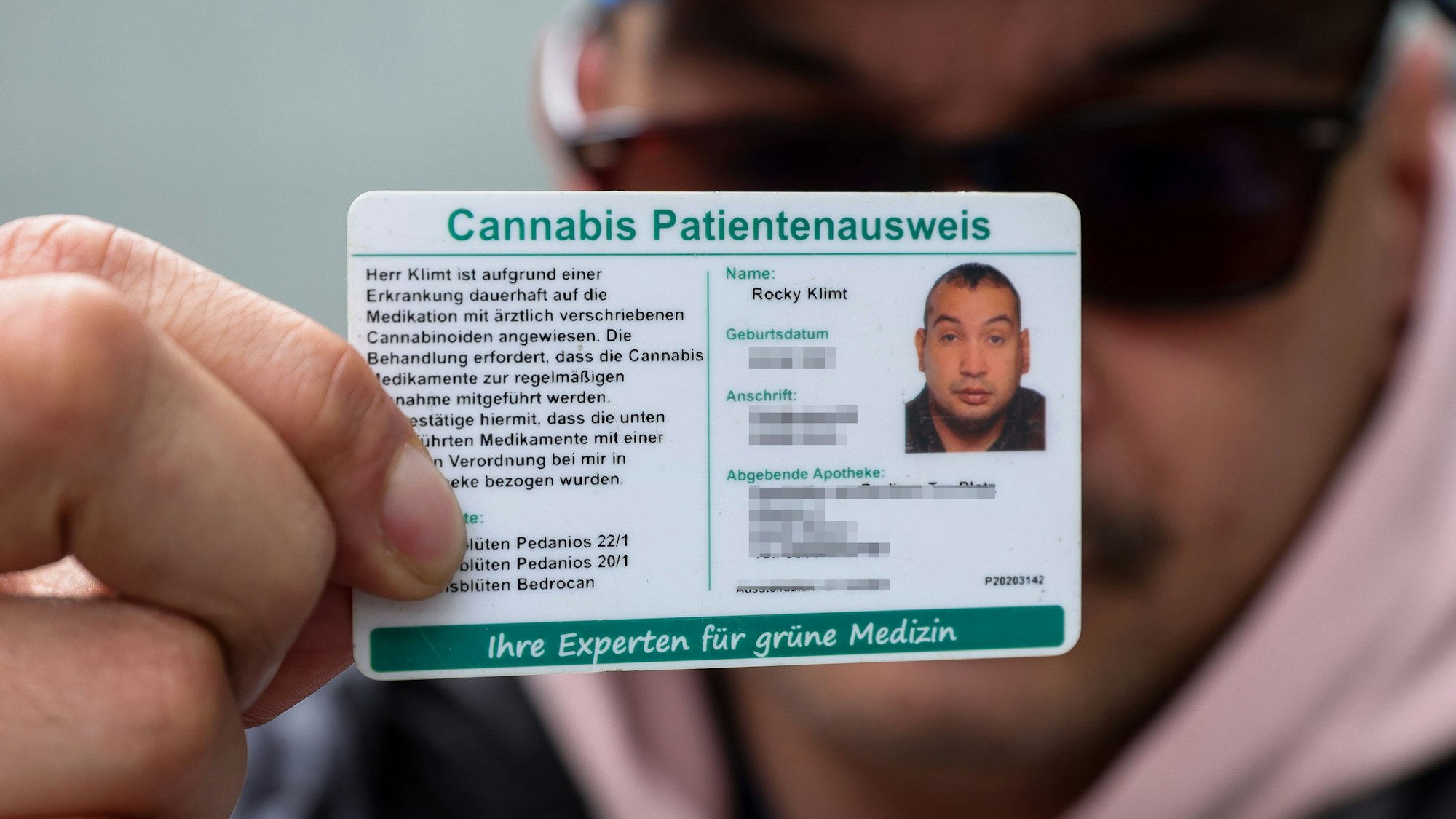 Rocky Klimt hält seinen Cannabis Patientenausweis in die Kamera.