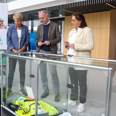 Doris Fitschen, Gesamtkoordinatorin Strategie FIFA Frauen-WM 2027, DFB-Präsident Bernd Neuendorf und DFB-Generalsekretärin Heike Ullrich schauen sich die Ausstellung zur Geschichte des Frauenfußballs an.