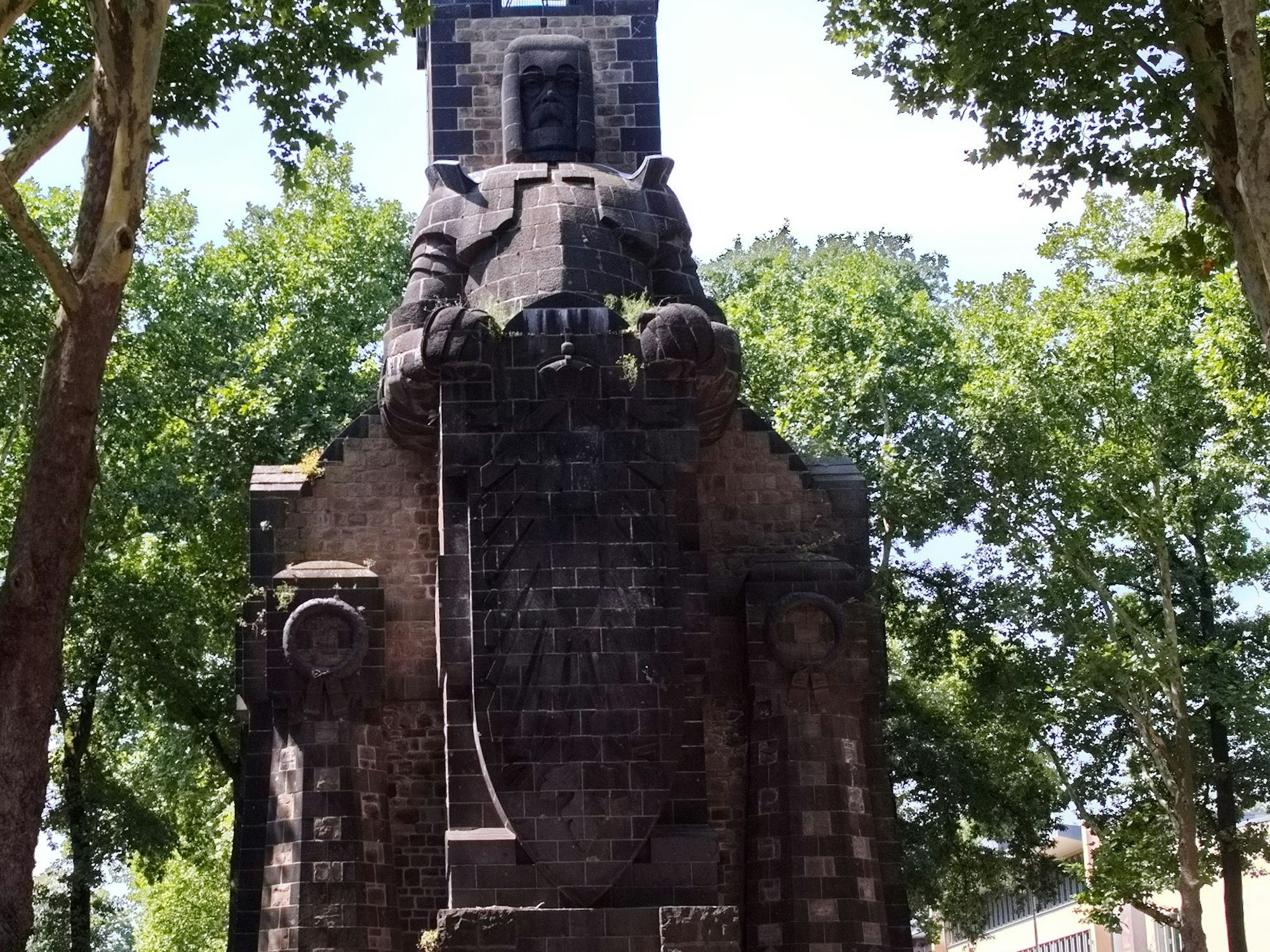 Eine Säule aus Stein steht inmitten von Bäumen.