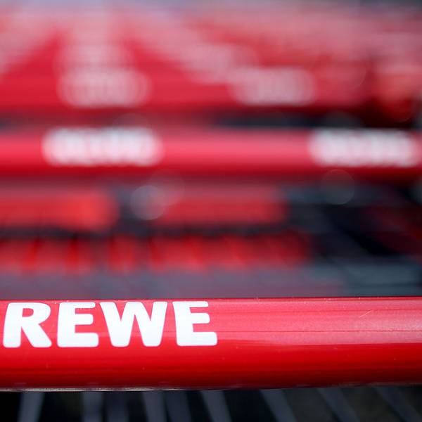 Einkaufswagen stehen vor einem Rewe-Supermarkt in Köln.
