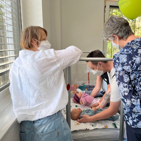 Pflegekräfte am Kinderbett.