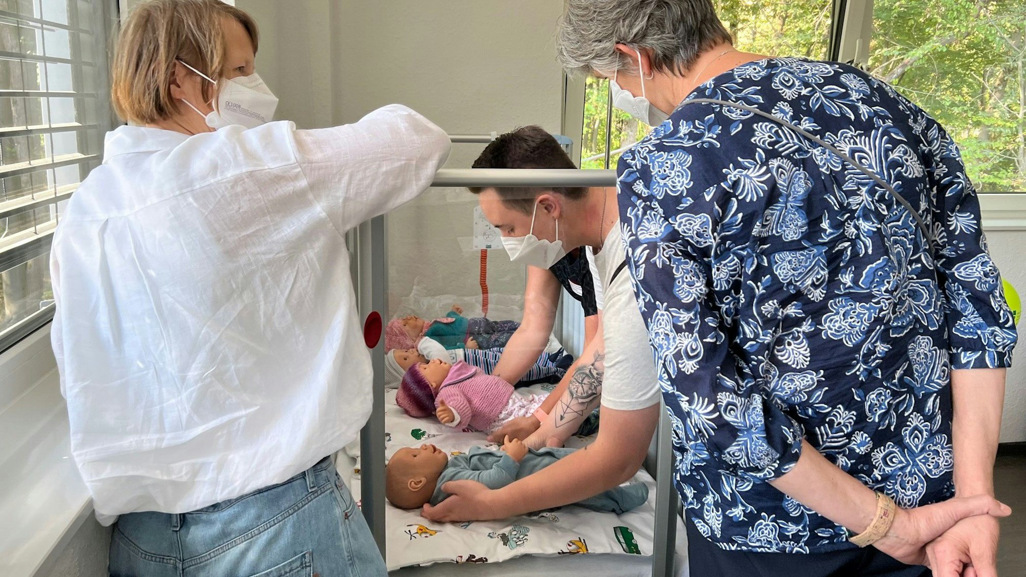 Pflegekräfte am Kinderbett.