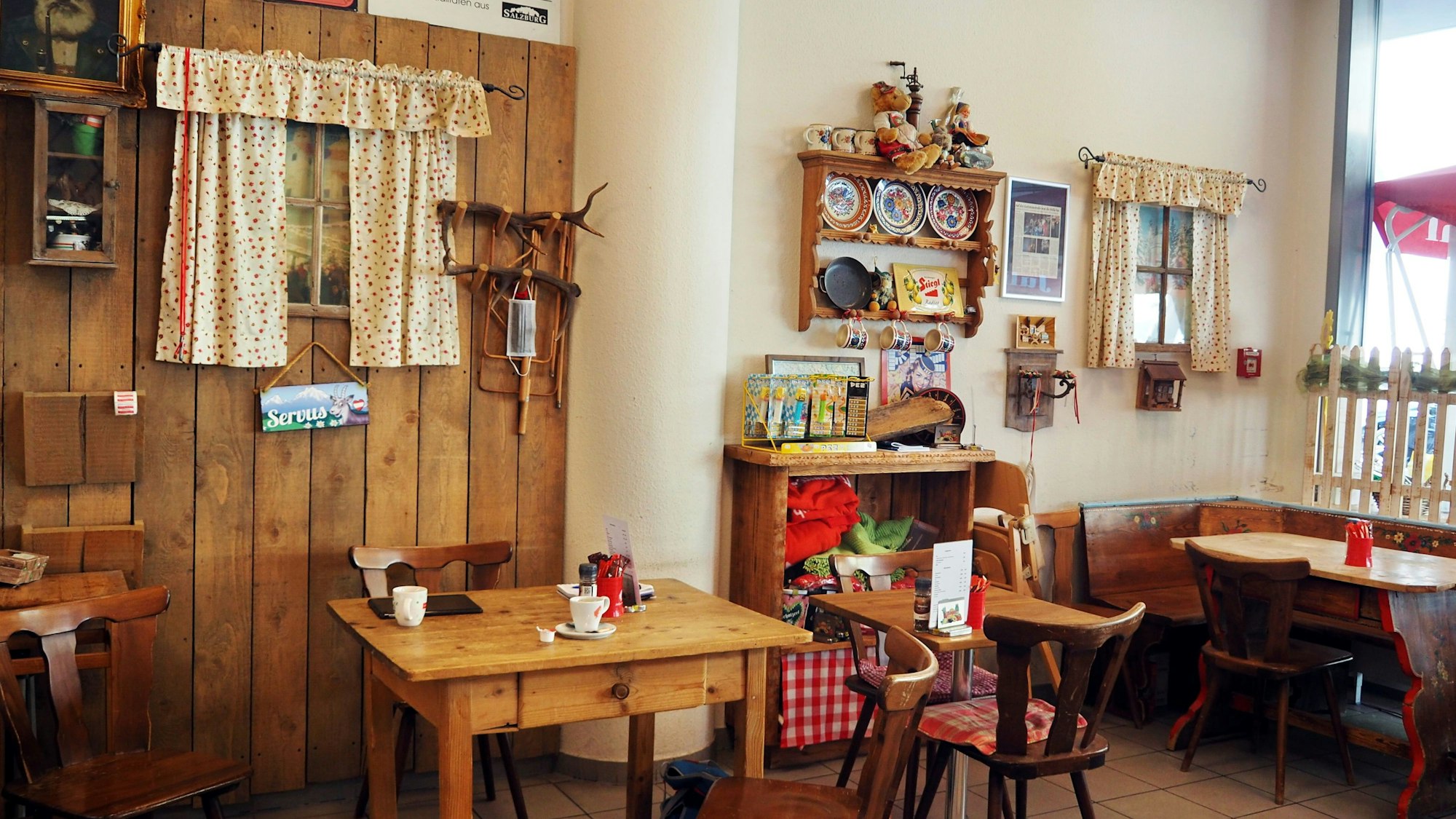 Holztische und -stühle stehen im Feinkostladen.