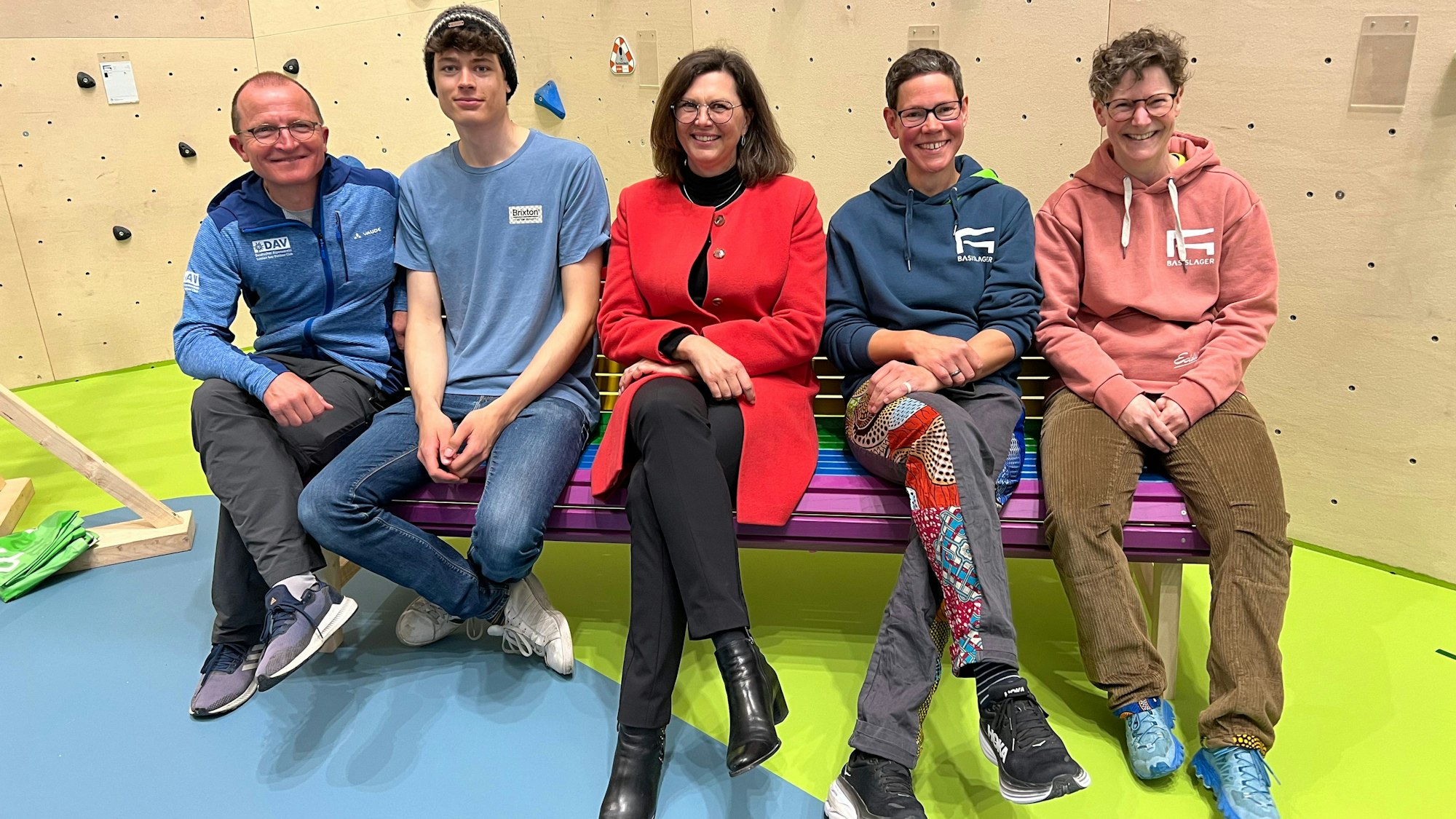 Die Herkenratherin Katja Müller (2. v.r.) sitzt neben der bayerischen Landtagspräsidentin Ilse Aigner bei der Eröffnung der Halle auf einer Bank vor einer Kletterwand.