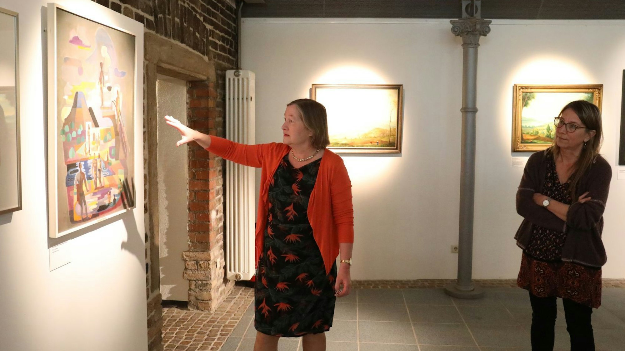 Zwei Frauen in einer Ausstellung mit Arbeiten von Carlo Mense.