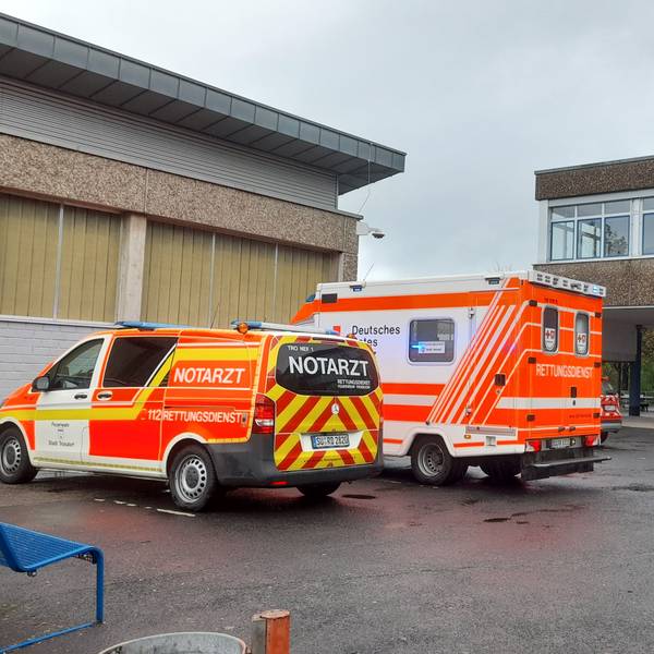 Ein Rettungswagen und ein Notarztwagen stehen auf dem Hof der Gesamtschule in Lohmar.