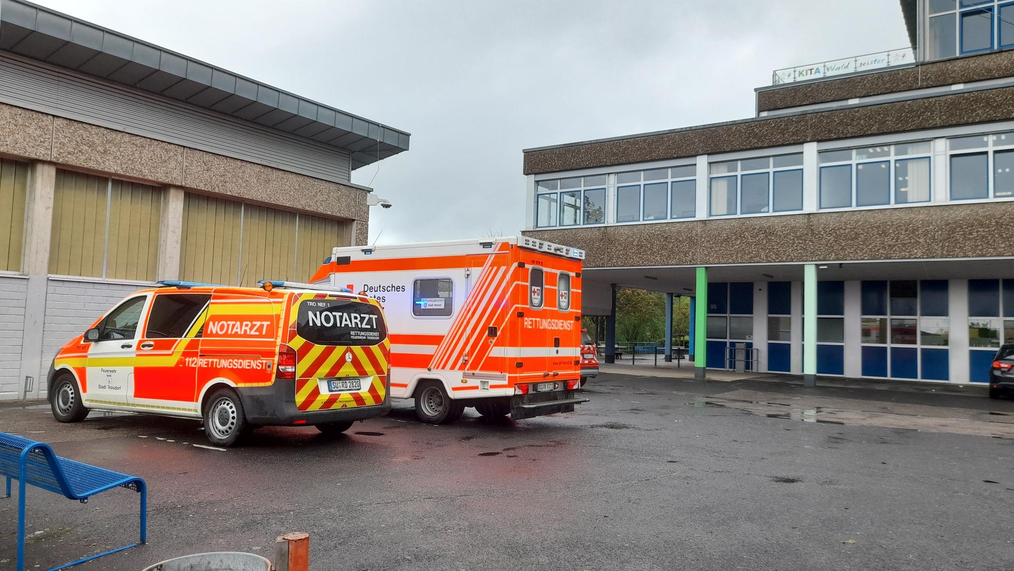 Ein Rettungswagen und ein Notarztwagen stehen auf dem Hof der Gesamtschule in Lohmar.