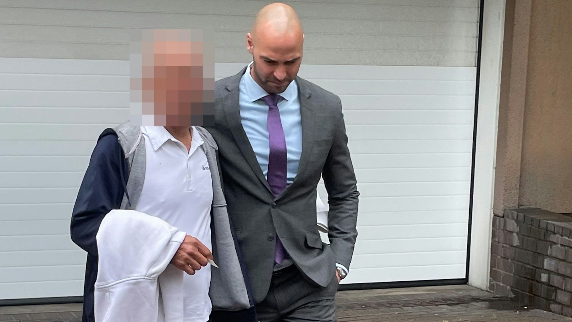 Als freier Mann verlässt der Angeklagte (l.) das Landgericht mit seinem Verteidiger Jan Victor Khatib.