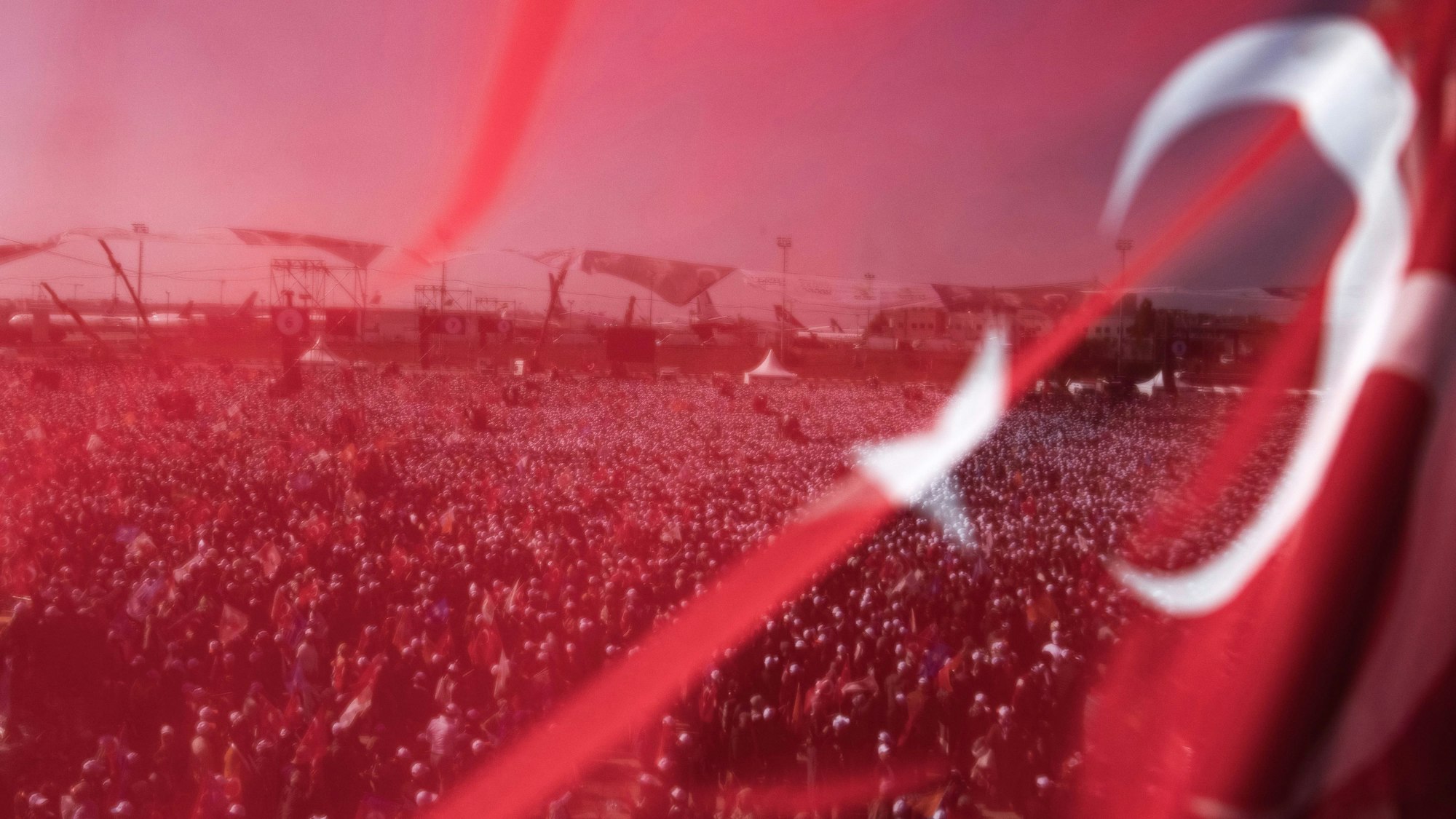 07.05.2023, Türkei, Istanbul: Anhänger des türkischen Präsidenten und Präsidentschaftskandidaten der Volksallianz Erdogan bei einer Wahlkampfveranstaltung hinter einer türkischen Fahne. Am 14. Mai finden in der Türkei die Parlaments- und Präsidentenwahlen statt. Foto: Khalil Hamra/AP +++ dpa-Bildfunk +++