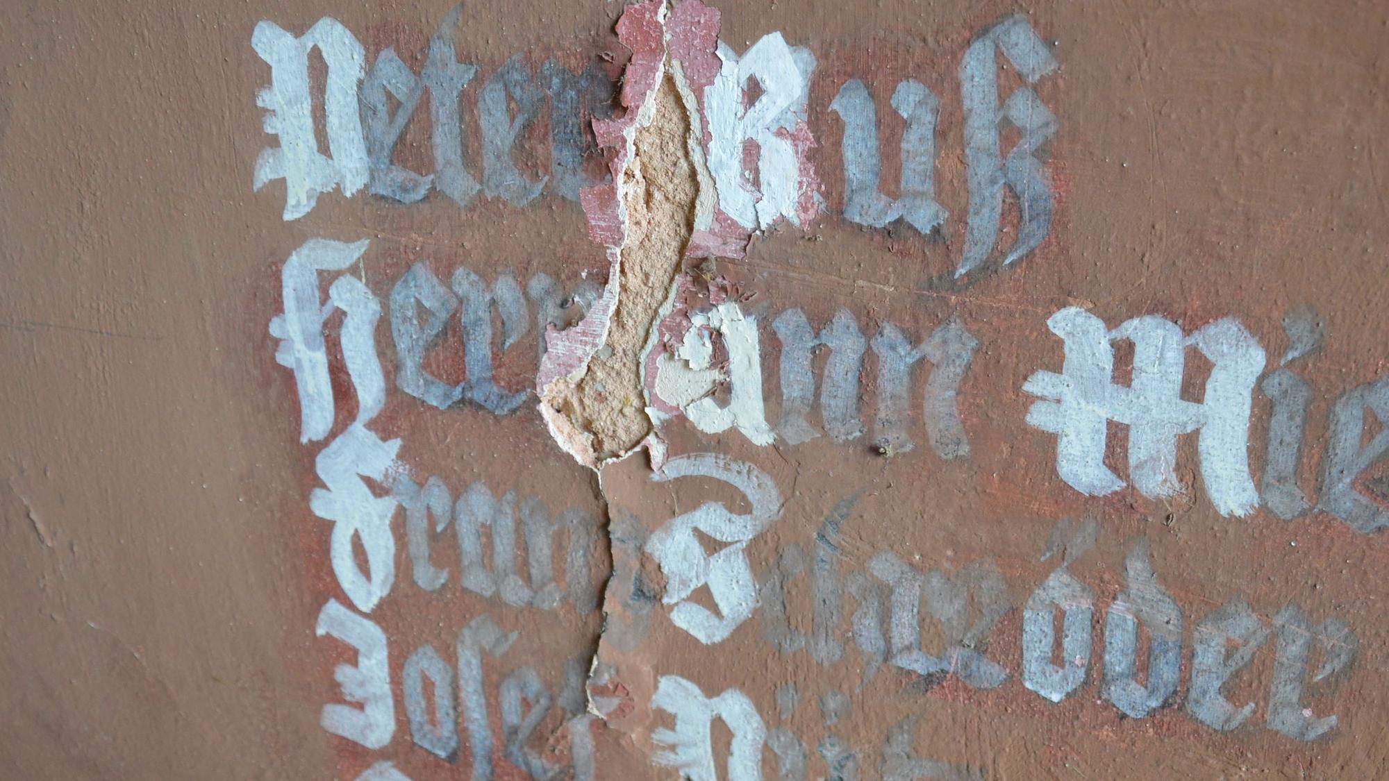 Ein Riss zieht sich durch die Schrift mit den Namen Gefallener.