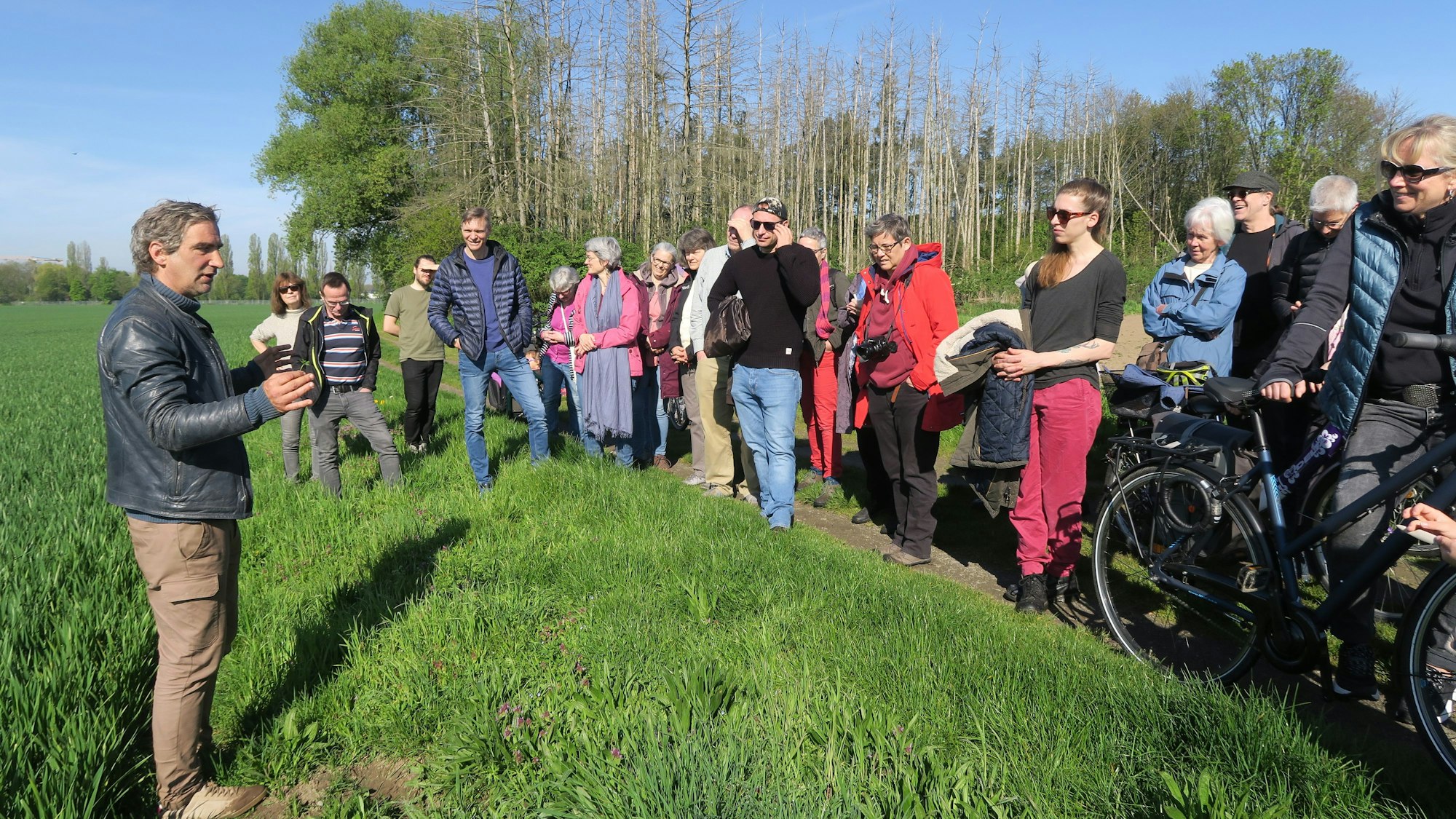 Die Teilnehmer stehen am Rand und hören zu.
