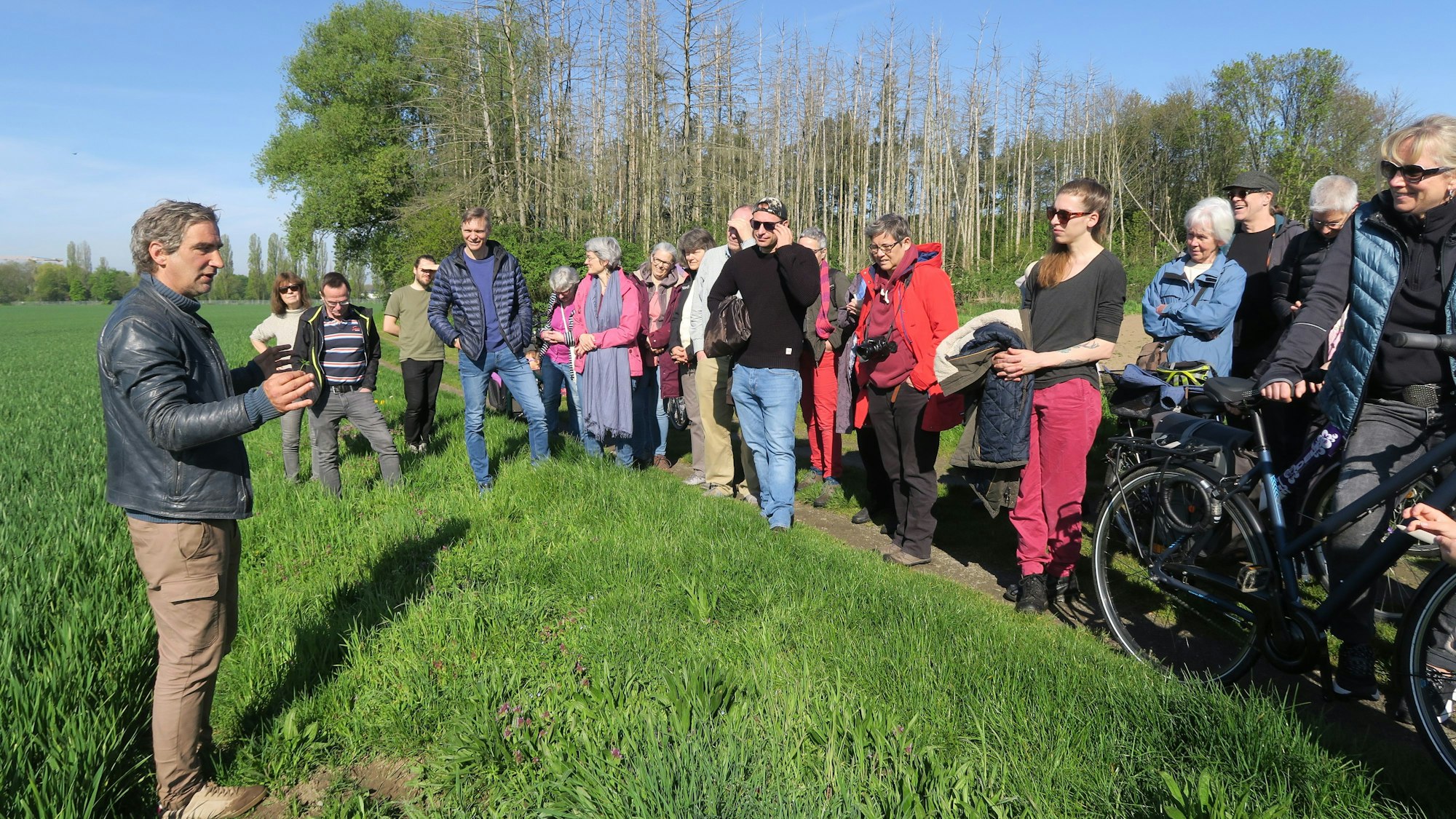 Die Teilnehmer stehen am Rand und hören zu.