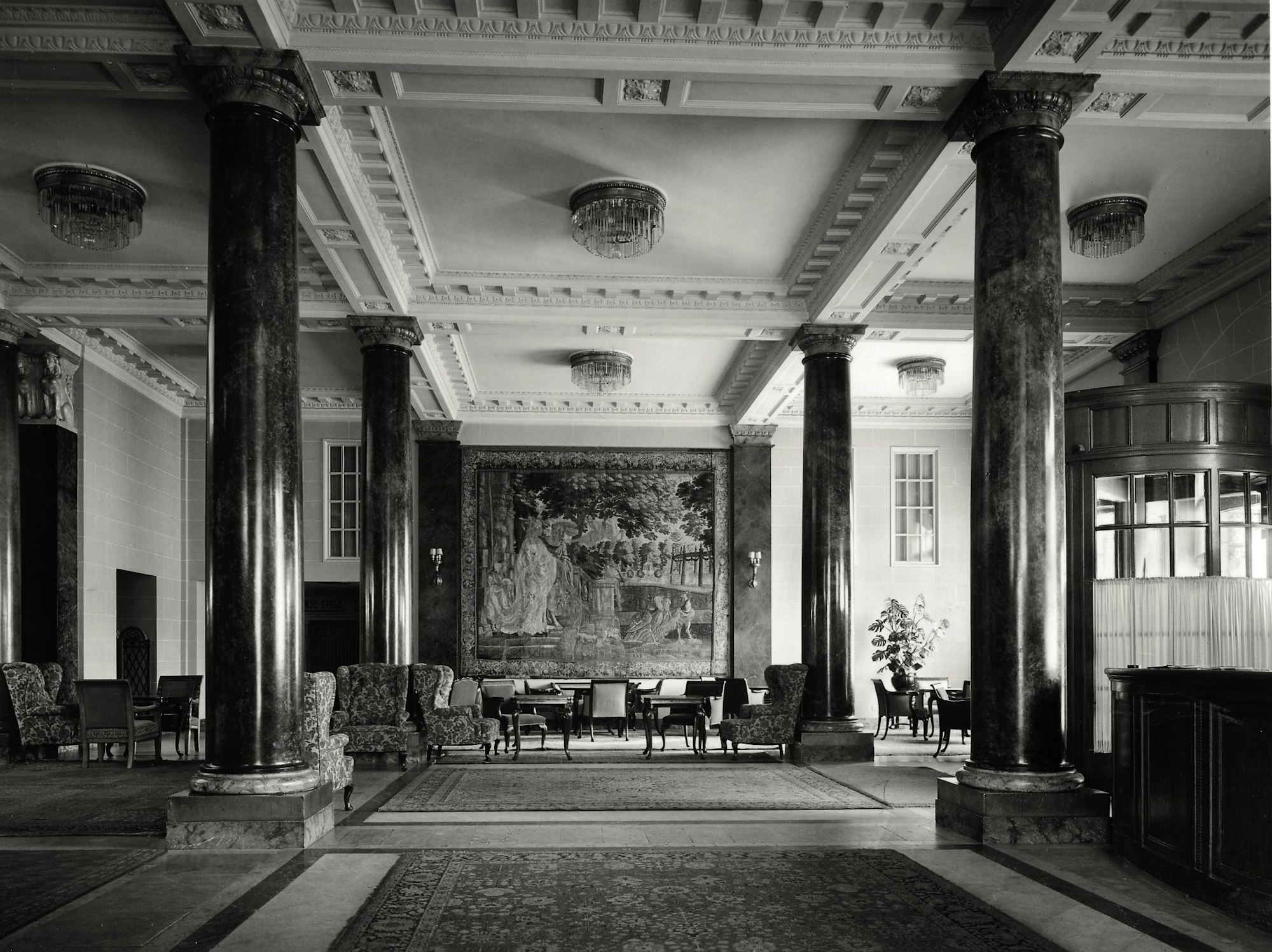 Die Empfangshalle 1926 mit hohen Säulen, Stuckdecke und Sitzgruppen.
