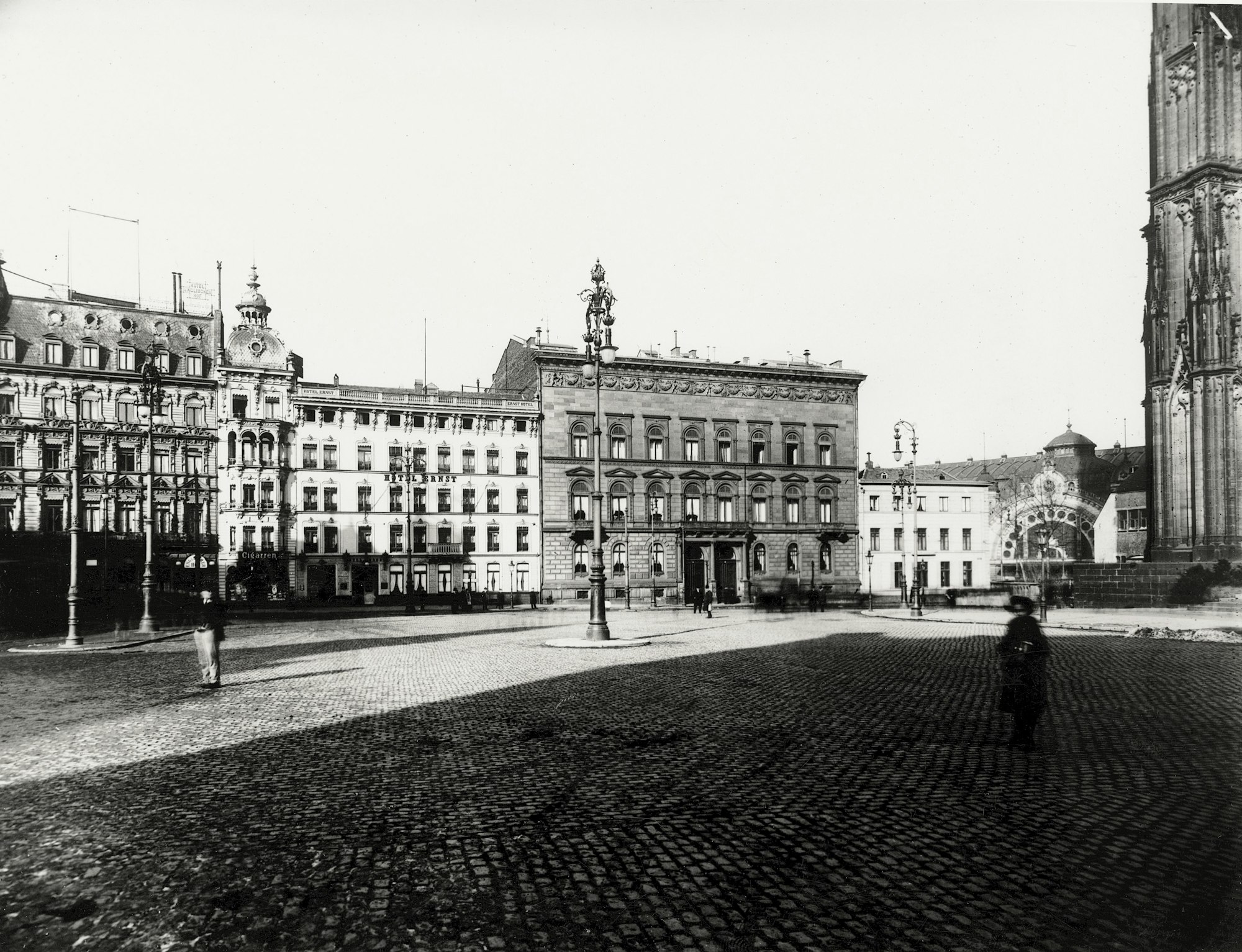 Das Hotel Ernst kurz nach seiner Gründung, rechts das Eingangsportal des Bahnhofs und eine Ecke des Doms.