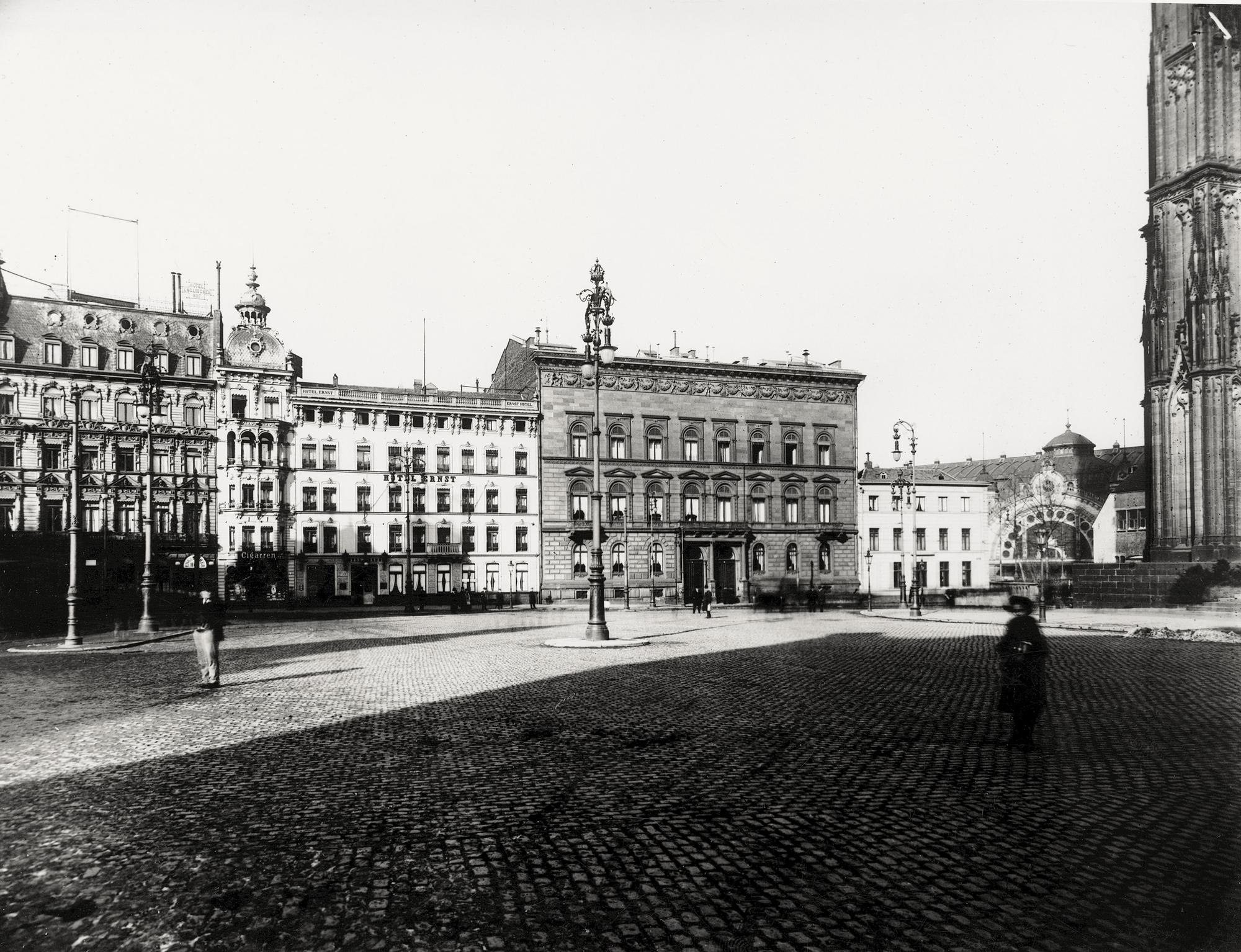 Das Hotel Ernst kurz nach seiner Gründung, rechts das Eingangsportal des Bahnhofs und eine Ecke des Doms.