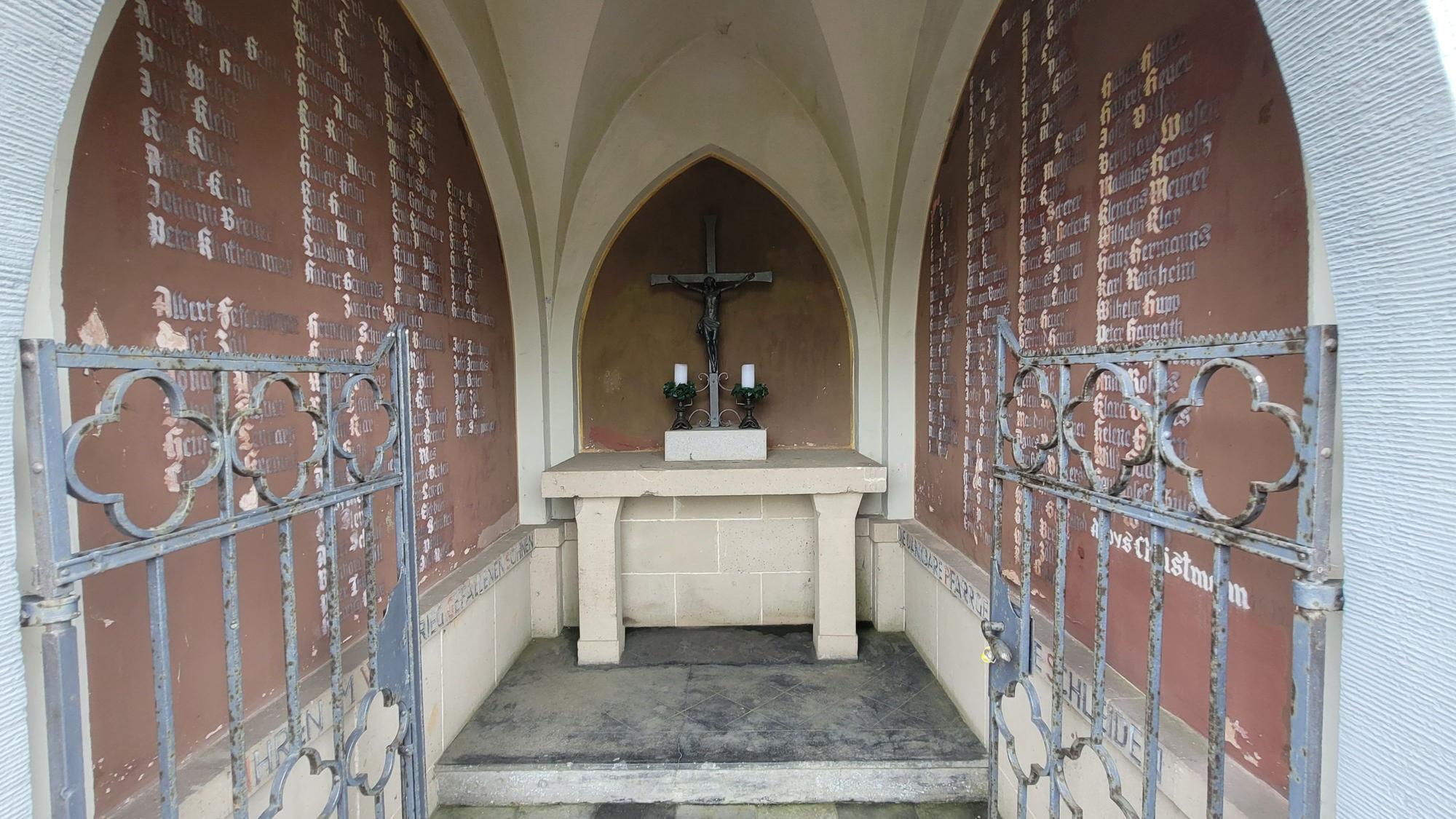 Der Blick durchs schmiedeeiserne Tor ins Innere der Kapelle. An den Seiten die Tafeln mit den Namen der in den beiden Weltkriegen gestorbenen Schleidener.