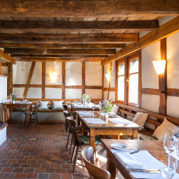 gedeckte Holztische in einem Raum mit Fachwerk-Wänden