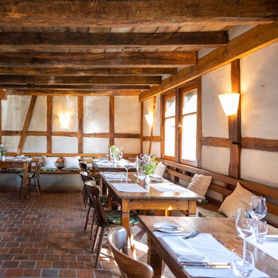 gedeckte Holztische in einem Raum mit Fachwerk-Wänden