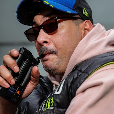 Porträt von Rocky Klimt, der an seinem Inhalator zieht, um Cannabis zu konsumieren.