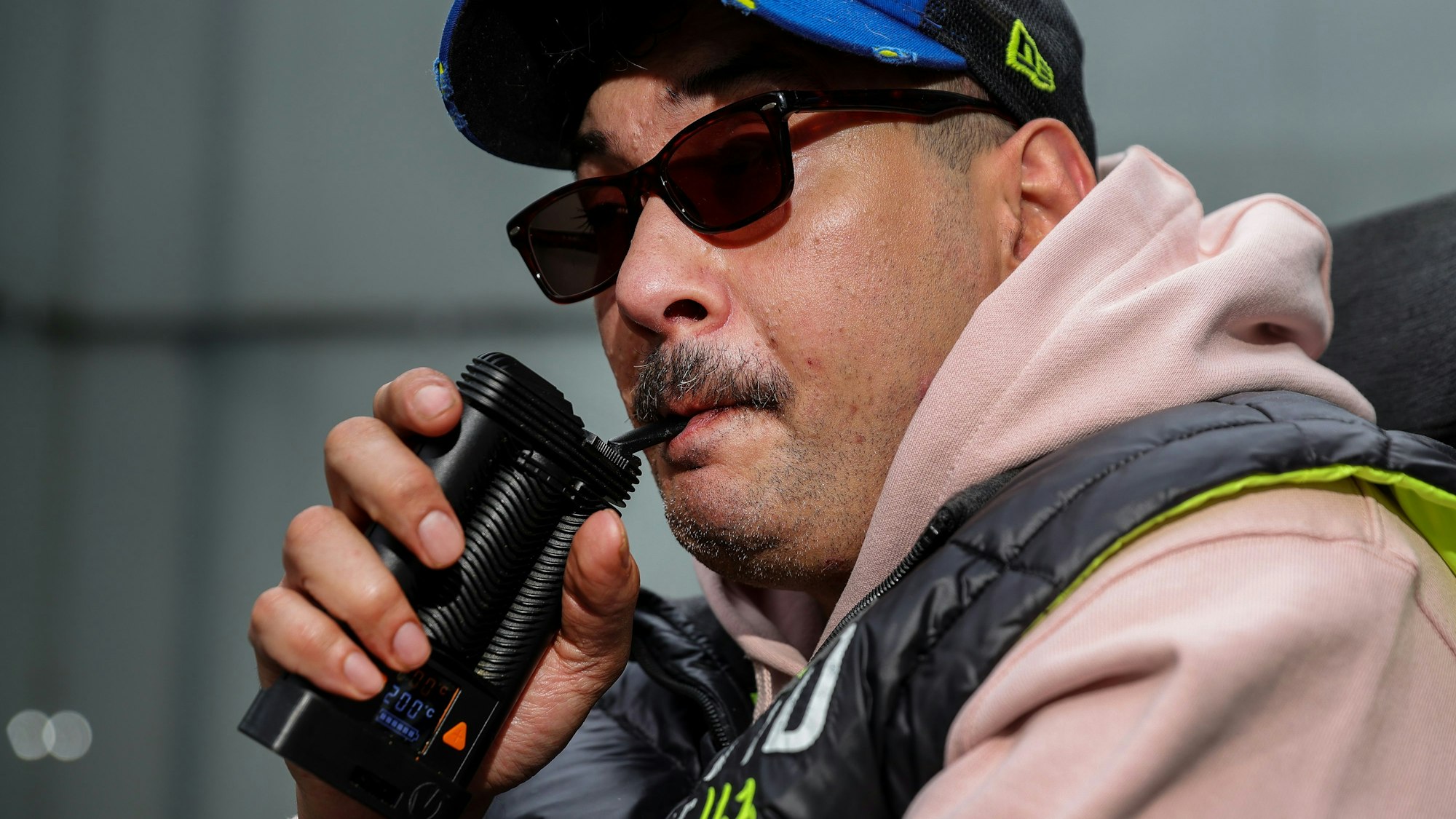 Porträt von Rocky Klimt, der an seinem Inhalator zieht, um Cannabis zu konsumieren.