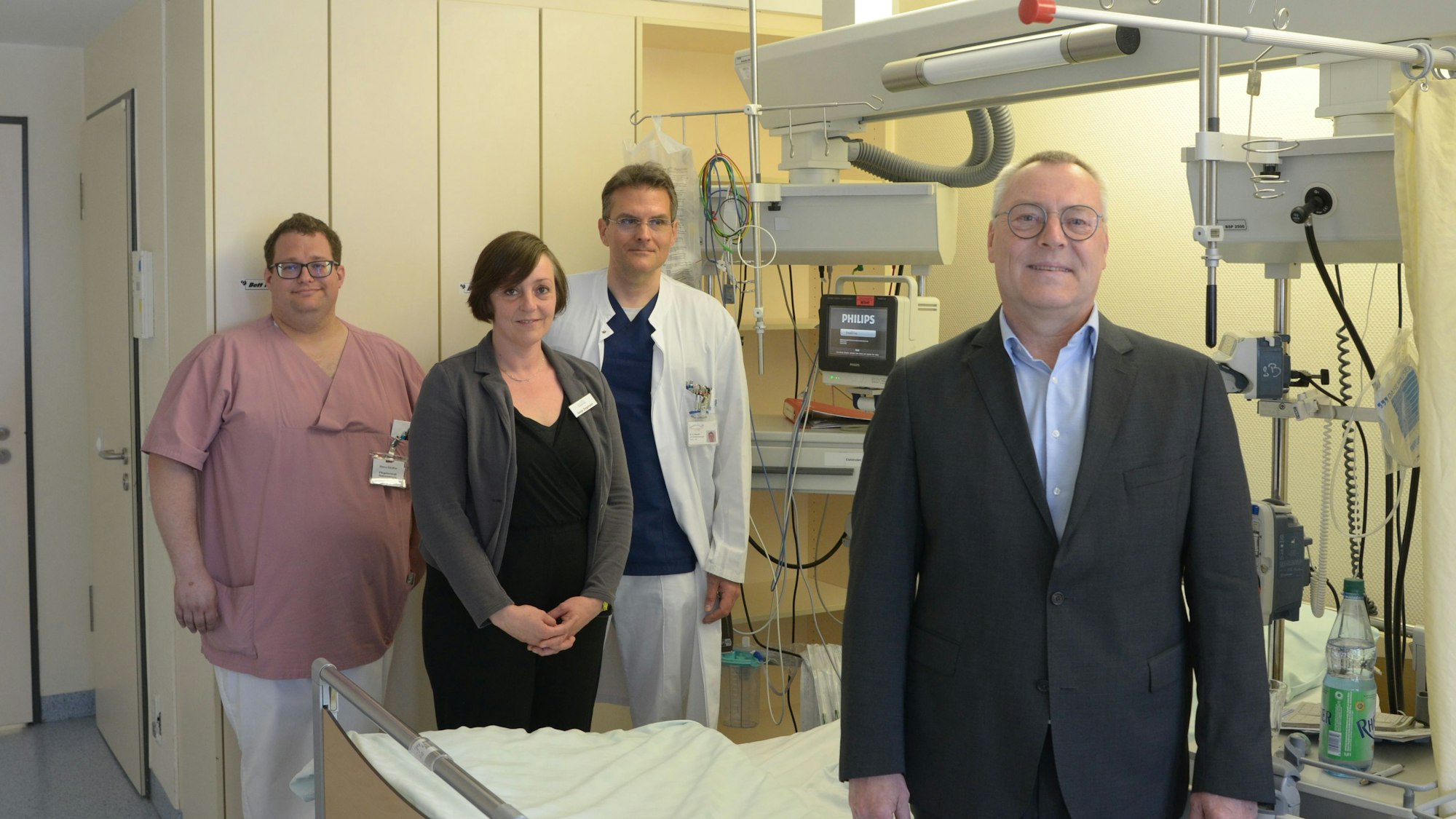 Der Neurologie-Chefarzt Dr. Hartmut Bauer (v.r.) und der leitende Oberarzt Dr. Gaius Masset mit der stellvertretenden Leiterin des Kreisgesundheitsamtes, Sonja Zingsheim, und Pflegefachkraft Marco Günther an einem Behandlungsbett der Stroke Unit.