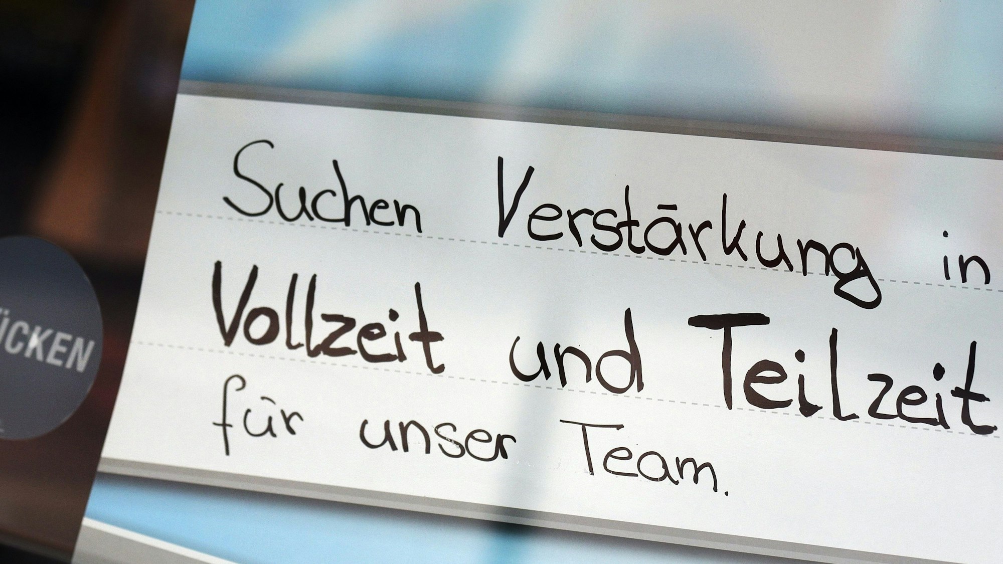 Eine Stellenanzeige in einer Glastür.