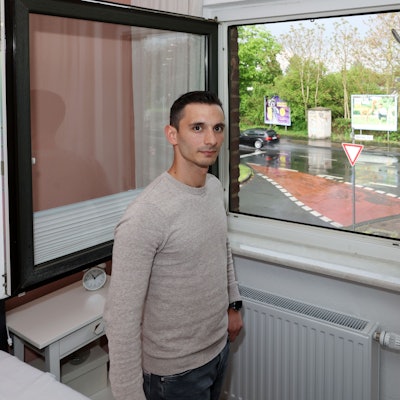 Muhammet Akcamuz aus Holweide steht in seinem Schlafzimmer vor dem Fenster, aus dem er einen Taxiräuber beobachtet hat.