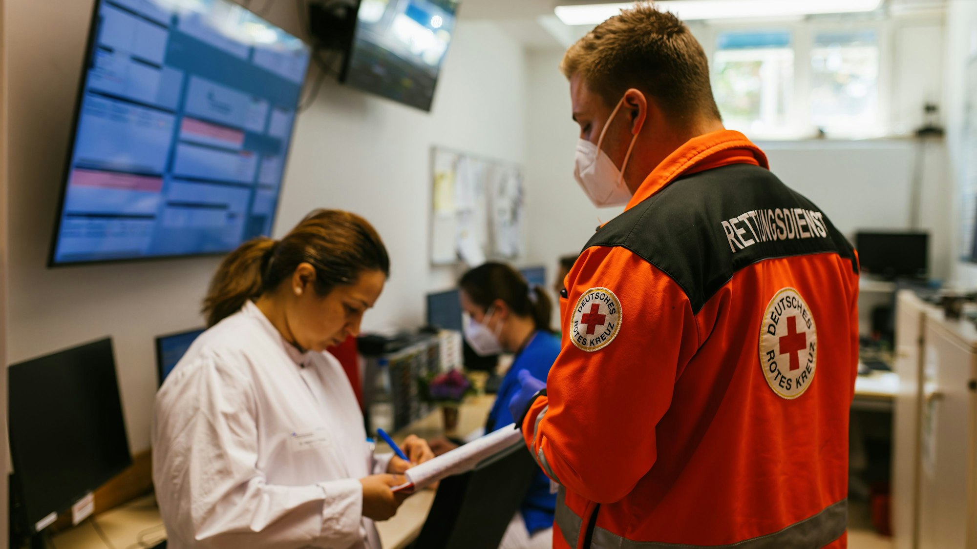 Notfallsanitäter Victor Durek spricht während einer sogenannten Übergabe mit einer Ärztin in der Notaufnahme des Theresienkrankenhaus.