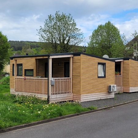 Blick auf zwei Tiny-Häuser, die am Straßenrand stehen.