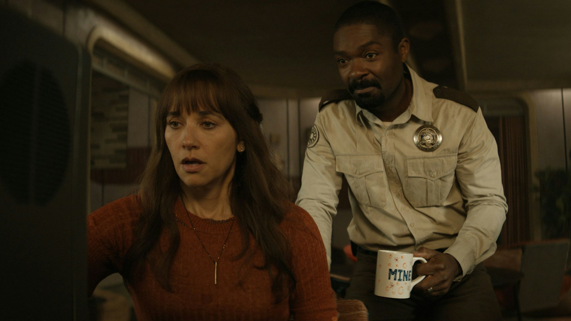 Eine Frau und ein Polizist schauen auf einen Bildschirm.