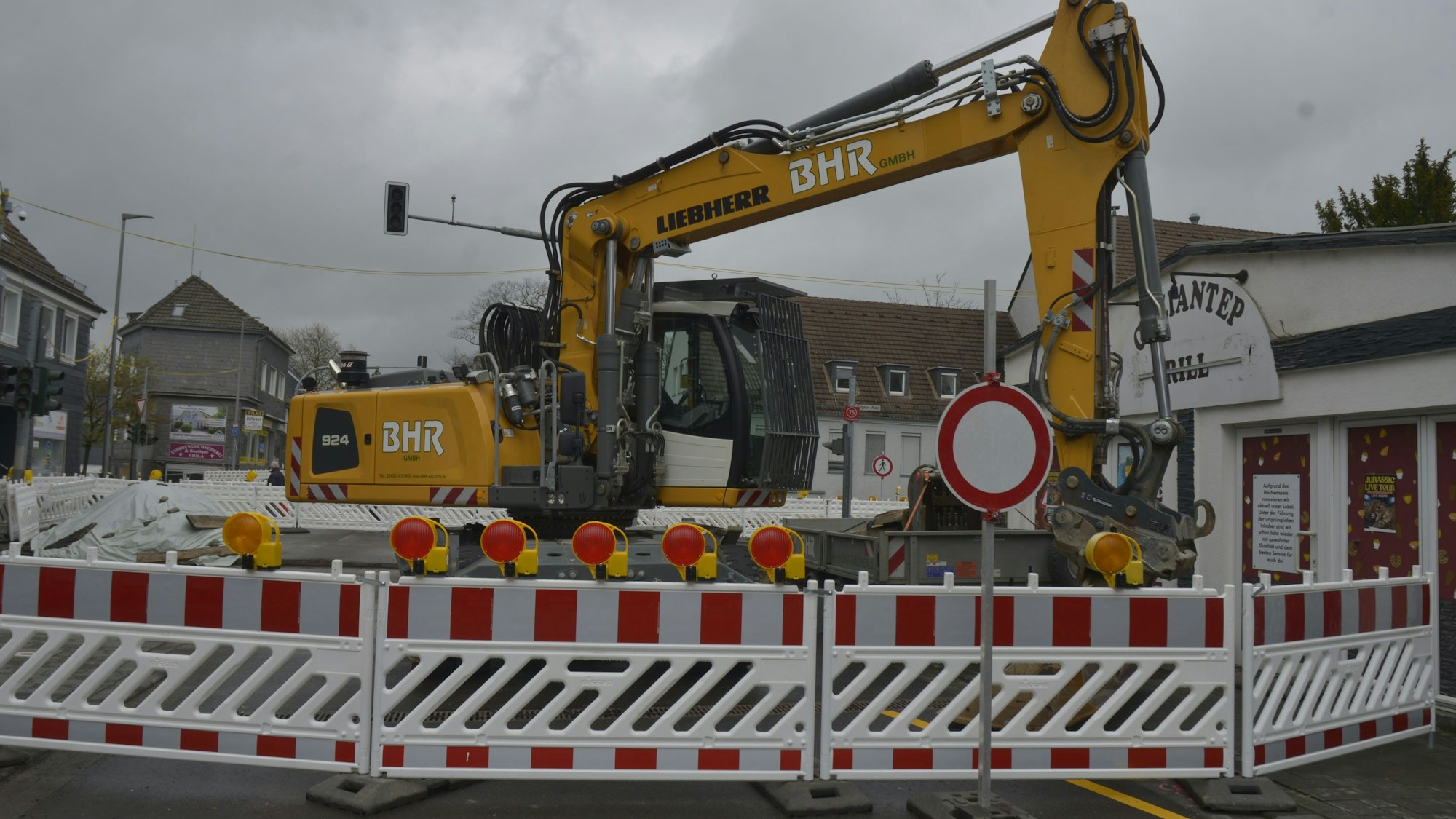 Die Baustelle ist zu sehen. Ein Bagger steht hinter der Absperrung.