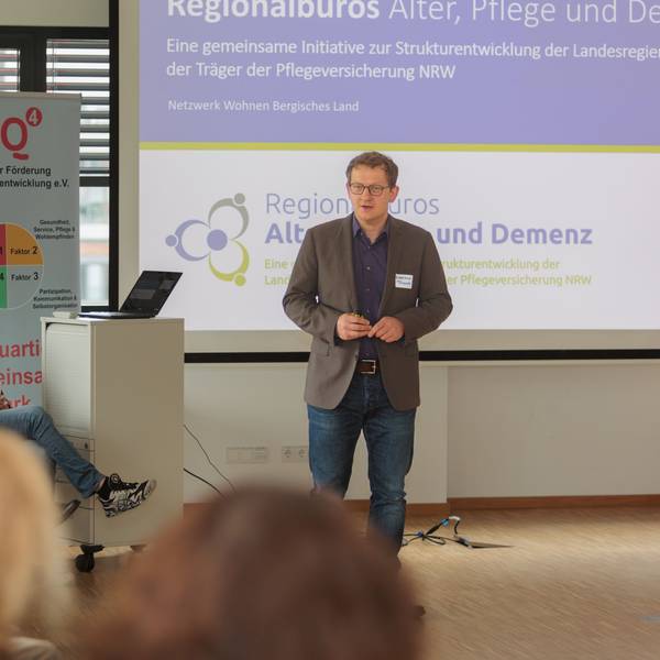 Dietmar Fischer steht vor Publikum und präsentiert.