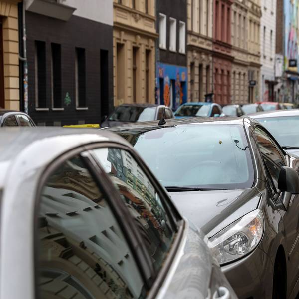Mehrere Autos stehen auf Parkplätzen hintereinander.