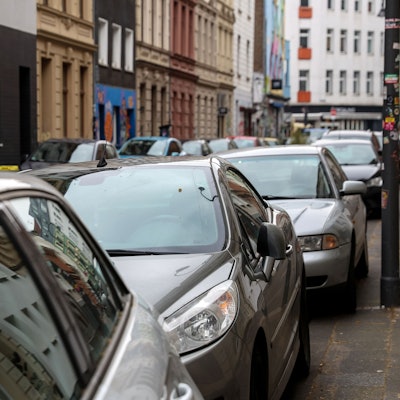 Mehrere Autos stehen auf Parkplätzen hintereinander.