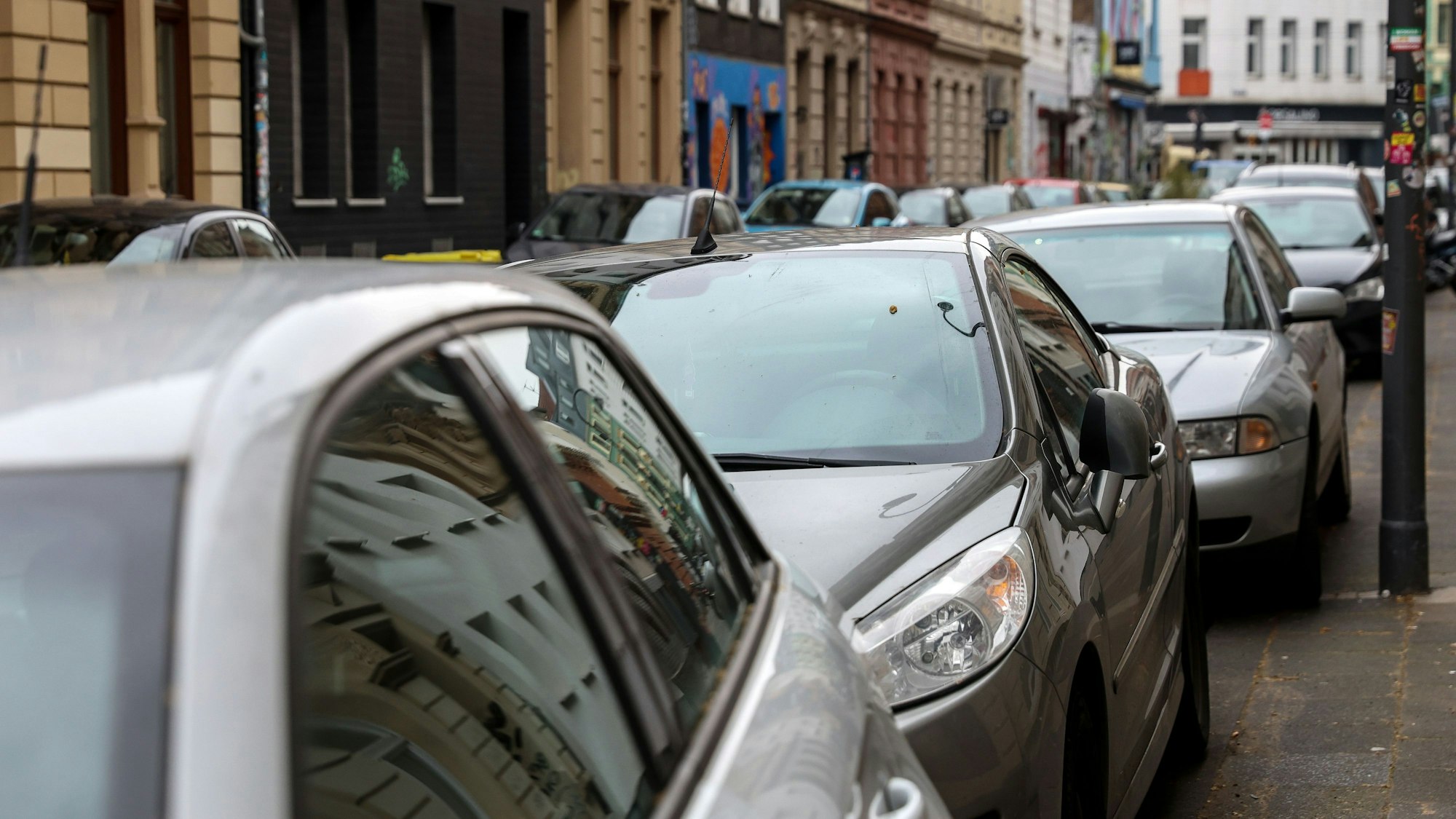 Mehrere Autos stehen auf Parkplätzen hintereinander.