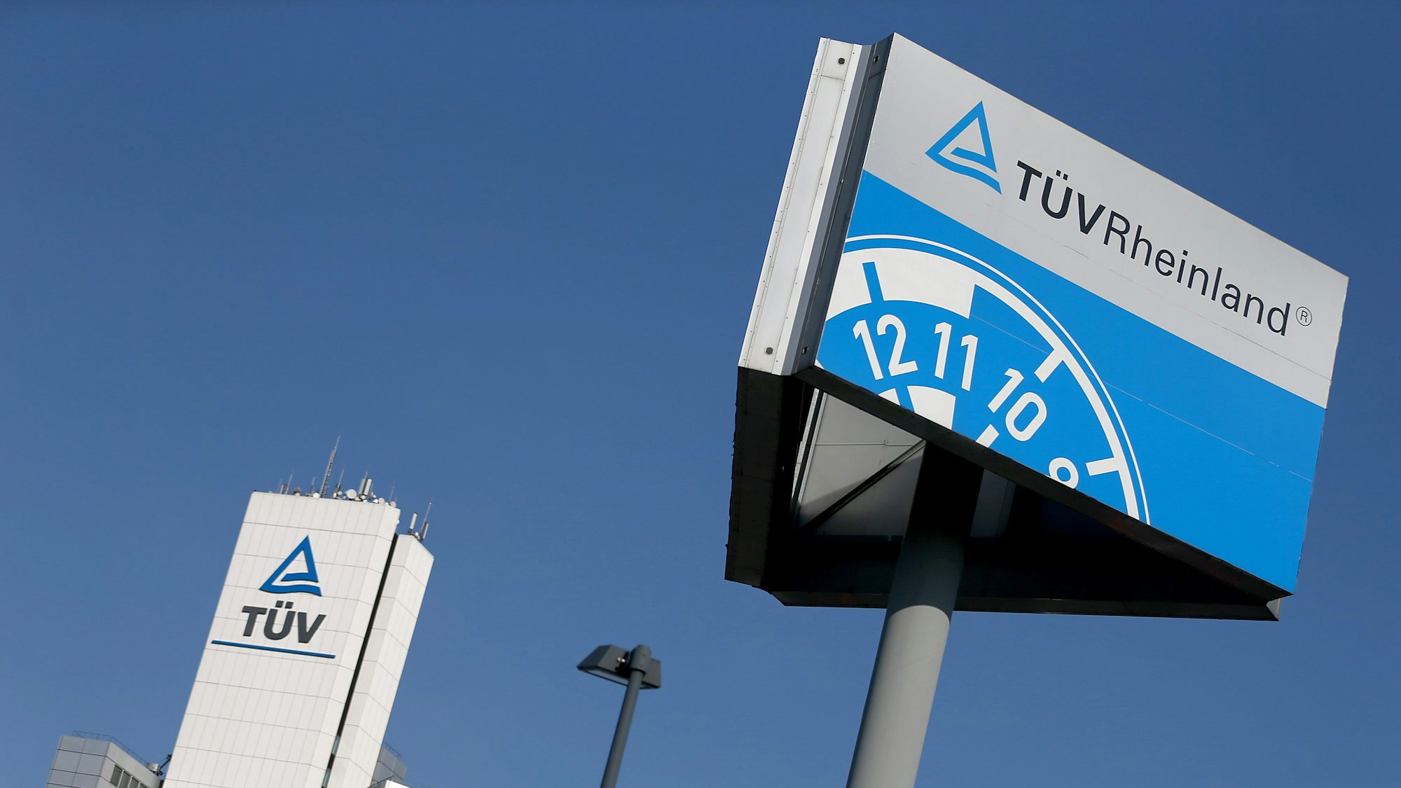 ARCHIV - 16.04.2019, Nordrhein-Westfalen, Köln: Ein Hinweisschild einer Kfz-Prüfstelle des TÜV Rheinland steht neben der Unternehmenszentrale. (zu dpa: «Tüv Rheinland wächst kräftig - Nachfrage nach Schulungen zieht an») Foto: Oliver Berg/dpa +++ dpa-Bildfunk +++