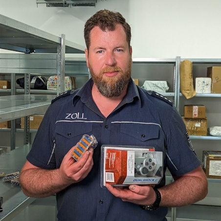 Jens Ahland vom Hauptzollamt Köln zeigt gefälschte Rasierklingen und einen nachgemachten Playstation-Controller.