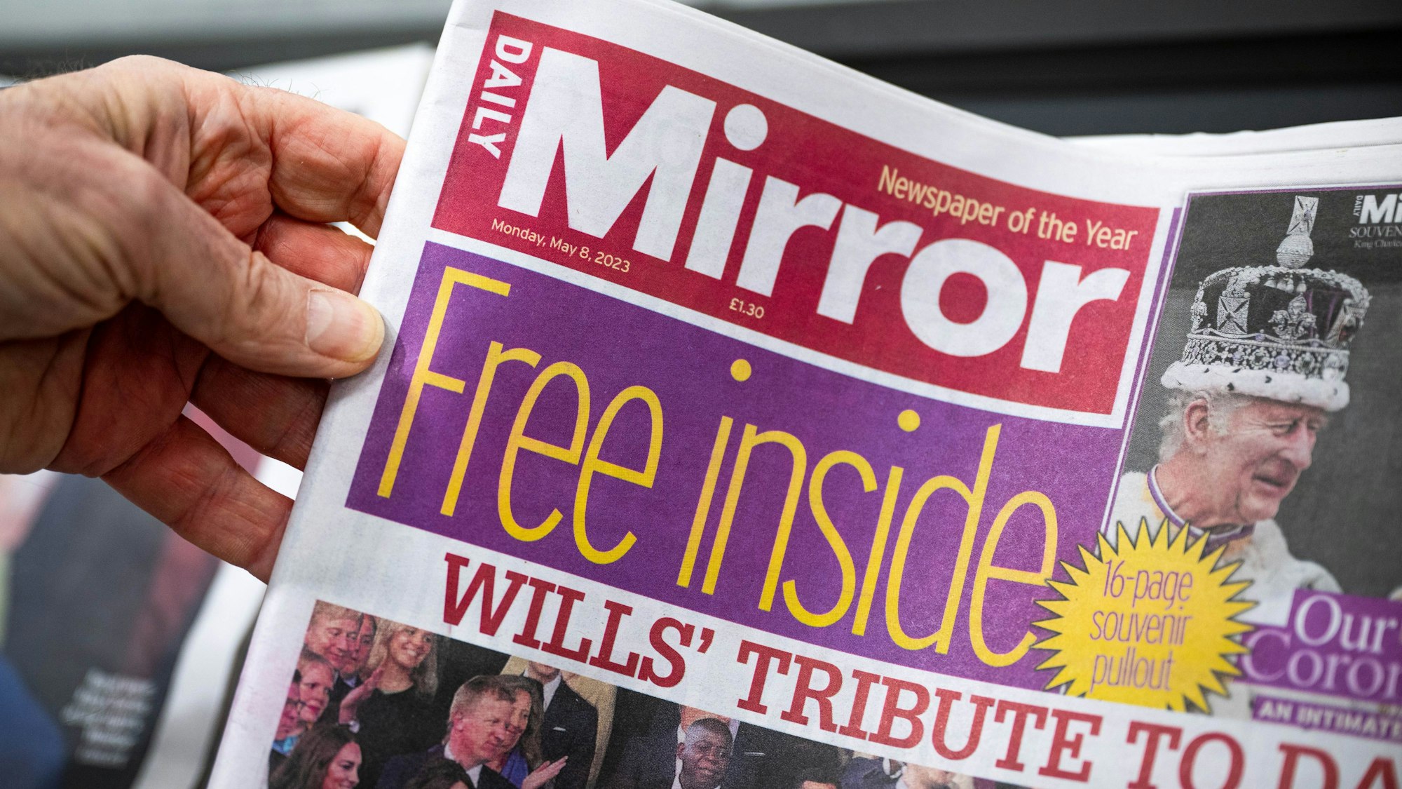 Eine Hand hält die britische Zeitung „Daily Mirror“.
